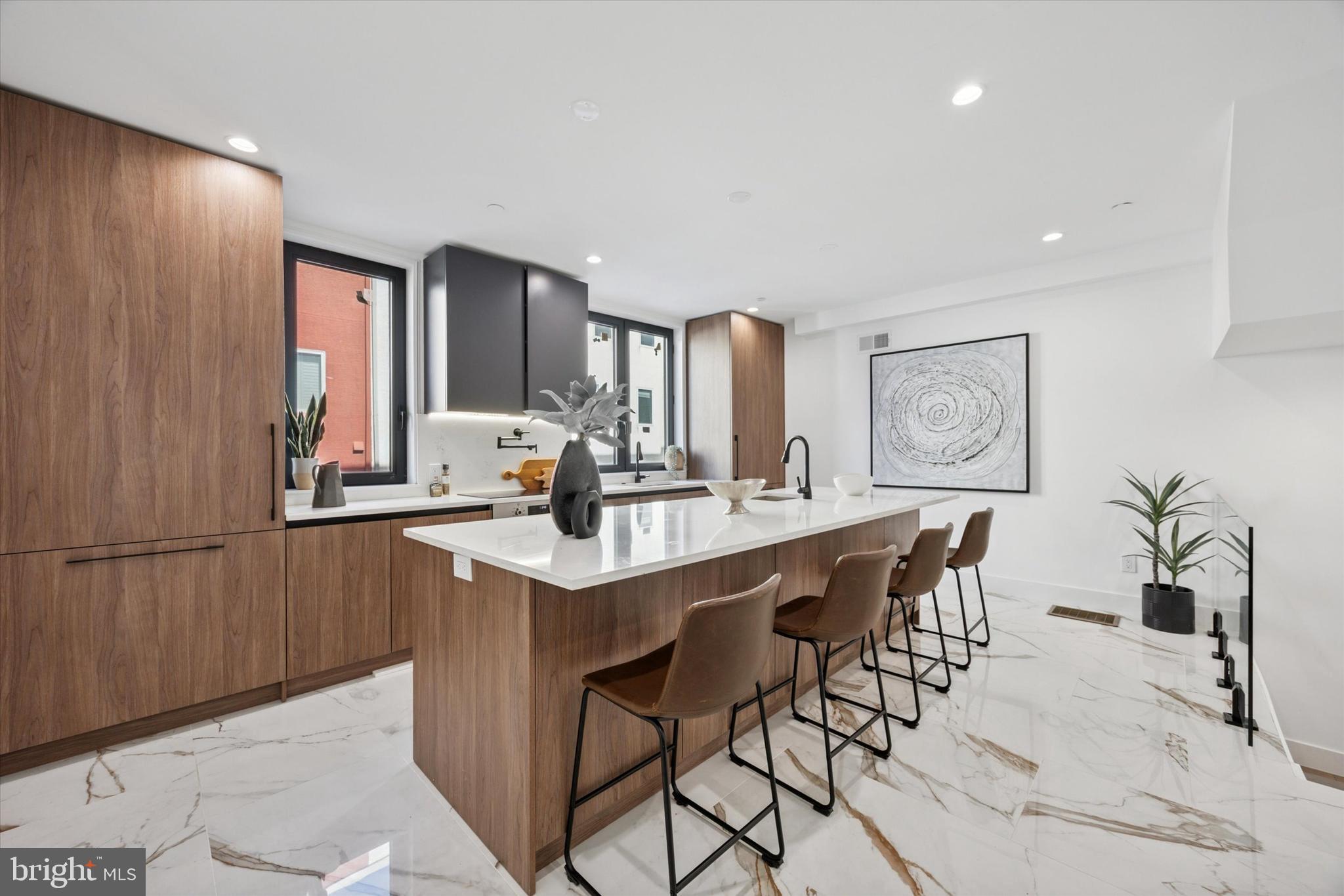 Introducing Parkside South, Philadelphia’s premier gated enclave of contemporary luxury townhomes in Packer Park. Experience refined city living in this private community featuring a collection of 4- and 5-bedroom residences with two-car garages, 5 stop elevators, expansive rooftop decks, and approved tax abatements. Parkside South combines modern architecture, sophisticated design, and everyday comfort into one seamless lifestyle. Each home showcases an open-concept floor plan drenched in natural light through imported Italian floor-to-ceiling windows. Sleek Italian tile flows throughout, setting the tone for a clean, elegant aesthetic. This unit offers 4 bedrooms and 4.5 bathrooms, designed with every detail in mind, from thoughtful layout to premium finishes. The chef’s kitchen is a true showpiece, featuring cabinet-integrated appliances, a built-in wine refrigerator, an oversized central island for entertaining, and a spacious walk-in pantry. Upstairs, the primary suite serves as a private sanctuary with a spa-like bath that includes a soaking tub, rainfall shower, and radiant heated floors. Every secondary bedroom features an en-suite layout, balancing luxury with functionality. The rooftop deck elevates your living experience,  a stunning space to host guests or unwind while taking in the views of Philadelphia’s skyline, bridges, and sports arenas. Parkside South homes are equipped with smart home automation, allowing effortless control of dual-zone HVAC, lighting, surround sound, and garage systems directly from your phone or tablet. Designed for both comfort and convenience, each home includes secure gated access, private parking, and proximity to major highways, public transit, and the city’s top cultural attractions. Don't miss out on this opportunity to make Parkside South your home, reach out today!
