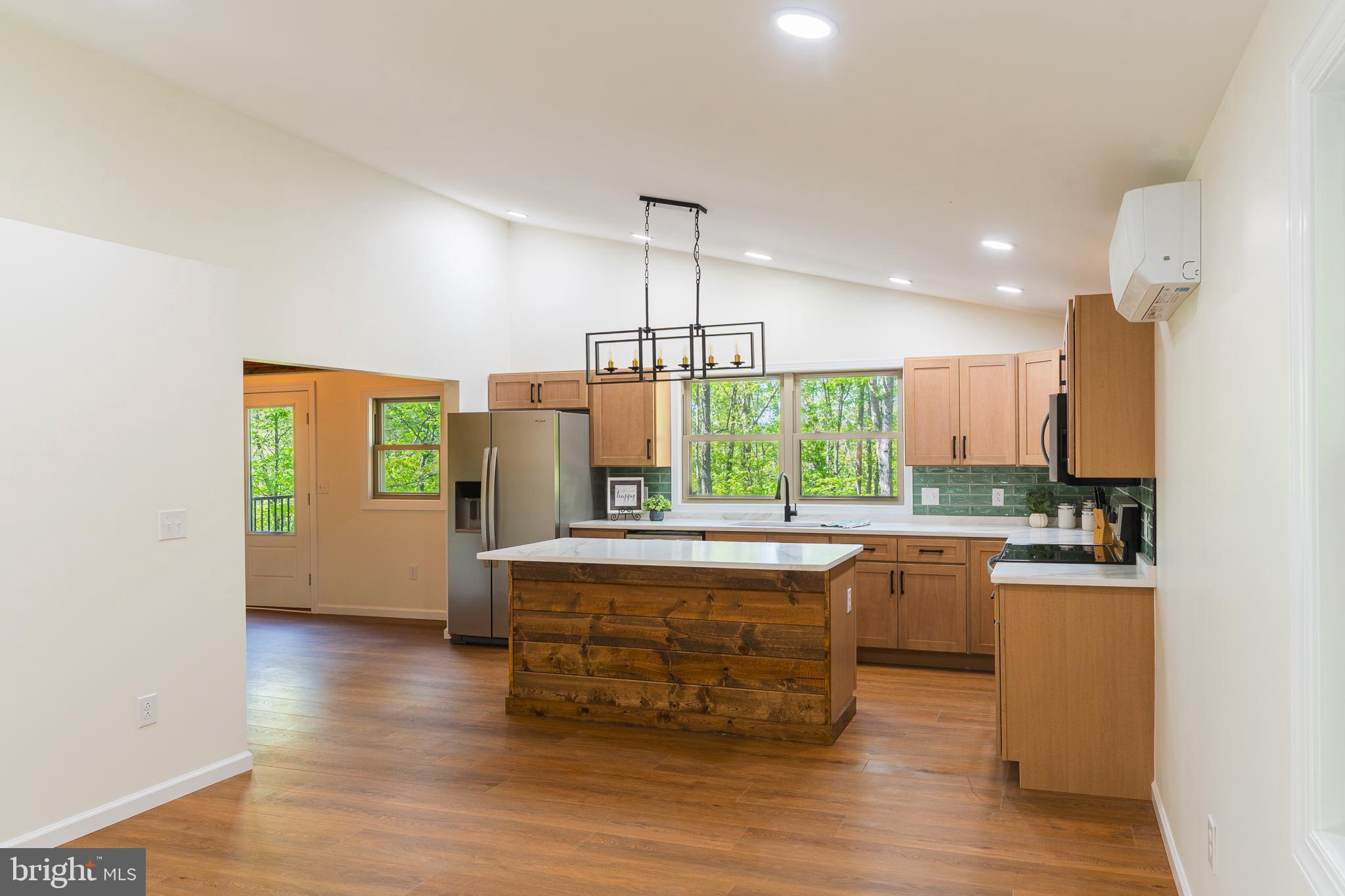 Stunning modern chalet in a private mountain lake community! This once rustic cabin has been completely transformed into a one-of-a-kind mountain/lake retreat, thoughtfully renovated with quality craftsmanship and materials—everything updated except the original framing. Tucked away in a hidden lake community in the WV hills, the home sits on a generous 5.62-acre parcel surrounded by towering hardwoods, offering exceptional privacy and natural beauty. Inside, you’ll find a show-stopping custom kitchen featuring quartz countertops, a large island, and brand-new stainless steel appliances. The open interior is highlighted by soaring vaulted ceilings with tongue-and-groove pine, creating a warm yet modern aesthetic. The enormous primary suite includes a walk-in closet and a beautifully finished bath with a custom tiled shower. The main bath also features a custom tiled shower along with a convenient utility area with washer and dryer. A versatile loft area provides additional space for a bedroom, office, or cozy sitting area. Step outside to a massive deck overlooking a fire-pit area—perfect for entertaining or relaxing under the stars. Perched on a hillside among towering oaks, the home is just a short distance from the community lake and beach, offering easy access to swimming, kayaking, and lakeside enjoyment. A rare opportunity to own a fully re-imagined mountain retreat that blends modern design with peaceful lake community living.