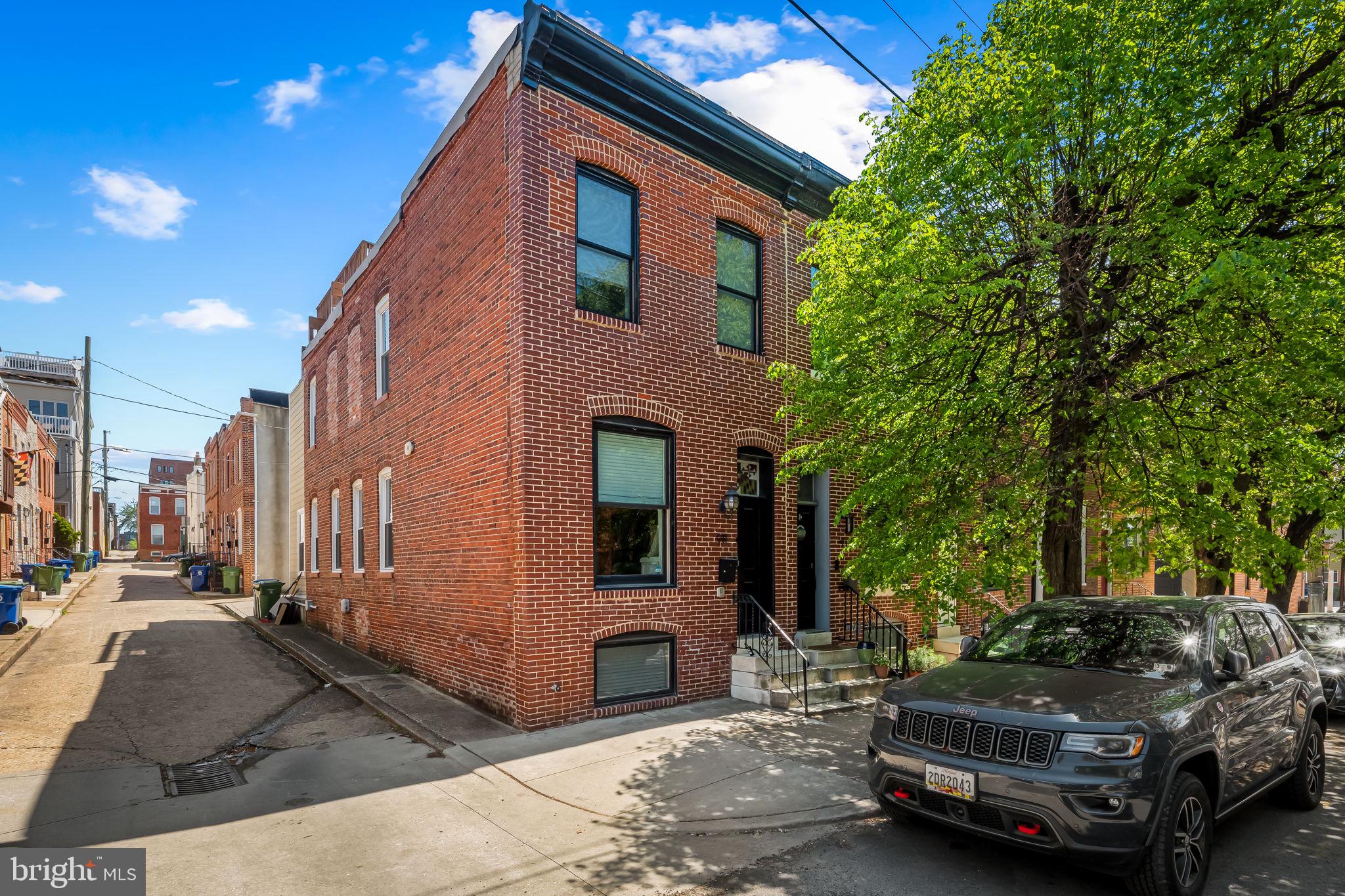Welcome Home to 911 S Highland - A stunning 4 bedroom, 3 bathroom end unit, brick front row home right in the heart of Canton. This property is located walking distance to Canton Square, Canton Waterfront, Patterson Park and all of the shopping, restaurants and entertainment that Canton has to offer! Every inch of this property was fully renovated by Baltimore's premier new home builder, Building Character, in 2014. Upon entry, you will be greeted by a show-stopping, Maryland flag, stained glass transom above the front door. Once in the foyer, you will step up into a large, sun-filled living room with exposed brick and tons of charm. The beautiful engineered hardwoods run throughout the entire home, flowing from the living room to the dining room space, large enough for a full sized dining table! Continuing on to the kitchen you will find a large island with barstool seating, pendant lighting, ample cabinet space, stainless steel appliances, granite countertops, a beautiful subway tile backsplash, built in wine racks and access to the rear of the home. Right outside of the back door, there is an oversized parking pad that can fit either a large SUV or 2 small cars if needed. Back inside, the kitchen leads to the basement where there are 2 large bedrooms and another beautiful, full bathroom. The upper level is a dream with 2 large bedrooms, including a primary suite with a gorgeous en-suite bathroom, a guest room, an additional hall bathroom and convenient upper level laundry! From the hallway of the upper level, you will enjoy access to the large rooftop deck, just waiting for you to enjoy evening cocktails or morning coffee with views of the city. The deck is also equipped with electrical and has speakers that connect to the whole-house-stereo system! If you have been looking for your next home in Canton, look no further! This is THE ONE! Schedule a showing today.