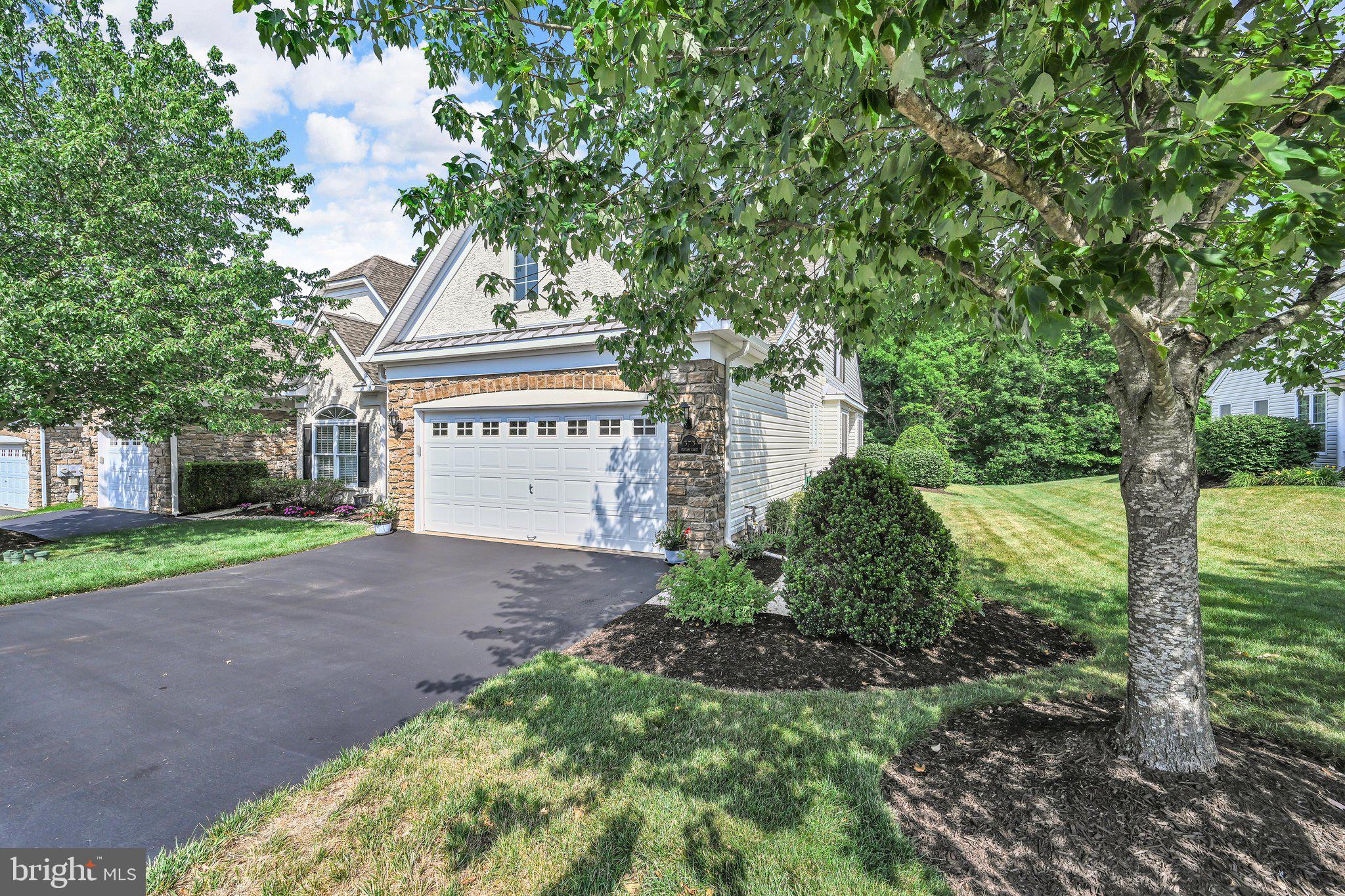 Spend more time enjoying life and less time working on it!!  This beautifully maintained end unit home in the heart of the desirable Harrington Village 55+ community backs to serene wooded open space and a scenic walking trail, this residence offers the perfect blend of privacy, space, and a vibrant, amenity-filled lifestyle.  Step inside to discover the inviting living space, where soaring cathedral ceilings and an open, flowing floor plan create an atmosphere perfect for both quiet relaxation and effortless entertaining. The heart of the home is a chef’s kitchen, complete with gas cooking, a HUGE pantry, and updated appliances.   The granite countertop offers bar seating for everyday living or meals on the go and a breakfast area for convenient table dining.    Living is made easy with a highly desirable main-level primary suite featuring two large walk-in closets and private bath, while a second main-floor bedroom and full bath offer comfortable accommodations for guests.   For even more flexibility, the finished upper-level loft serves as a second family room area, home office, craft/hobby room, or any other use needed.  The second floor also has a 3rd bedroom complemented by its own full bath perfect for guests to have a separate private area. Throughout the home, premium details like premium core tech luxury vinyl  flooring gas fireplace (great if power ever goes out) and upgraded carpeting elevate the sense of quality. With functional upgrades like a new HVAC system and hot water heater in 2023 (maintained annually) this home will offer peace of mind to protect your investment for years to come.   Transitioning outdoors, you can relax year-round in the sunroom or step onto the expanded rear patio to take in the tranquil, private wooded views. The sunsets and woods that change with the season are the perfect backdrop for enjoying coffee or a good book in the quiet private environment.  This serenity is paired with the ultimate convenience of the Harrington Village lifestyle. Residents enjoy a true "lock-and-leave," low-maintenance environment supported by outstanding amenities including a clubhouse, bocce courts, and scenic walking trails. With a rich calendar of social activities and a prime location just moments from premier shopping, dining, and major travel routes, this community offers the perfect balance of comfort and connection.   Schedule your tour today this one wont last!!!