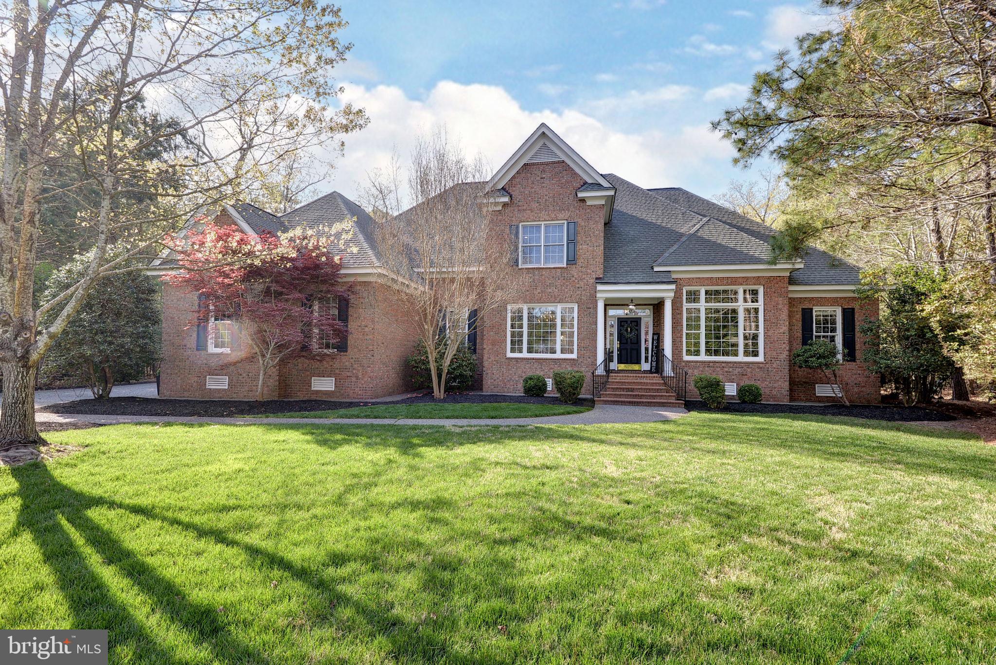 Set at the end of a cul-de-sac on over half an acre in highly desirable The Governor’s Land at Two Rivers, this elegant home offers soaring ceilings, beautiful natural light, and a gracious floor plan designed for comfortable living and easy entertaining. Refinished American Cherry hardwood floors and fresh interior paint create a bright, refreshed feel throughout. A cozy first-floor office adds flexibility for work or quiet retreat, while the massive primary suite features two large closets, a fireplace, and a spa-like bath with soaking tub and dual vanities. The spacious kitchen is the heart of the home, opening seamlessly to the family room and screened porch overlooking a secluded rear yard. Rich millwork, oversized windows, and three fireplaces add warmth and character throughout. A formal dining room is complemented by a separate serving pantry with dry bar, wine refrigerator, and added cabinetry. Upstairs, three well-sized bedrooms and two full baths complete the floor plan. Nearly 1,300 SF of unfinished attic space offers abundant storage or room for future expansion.