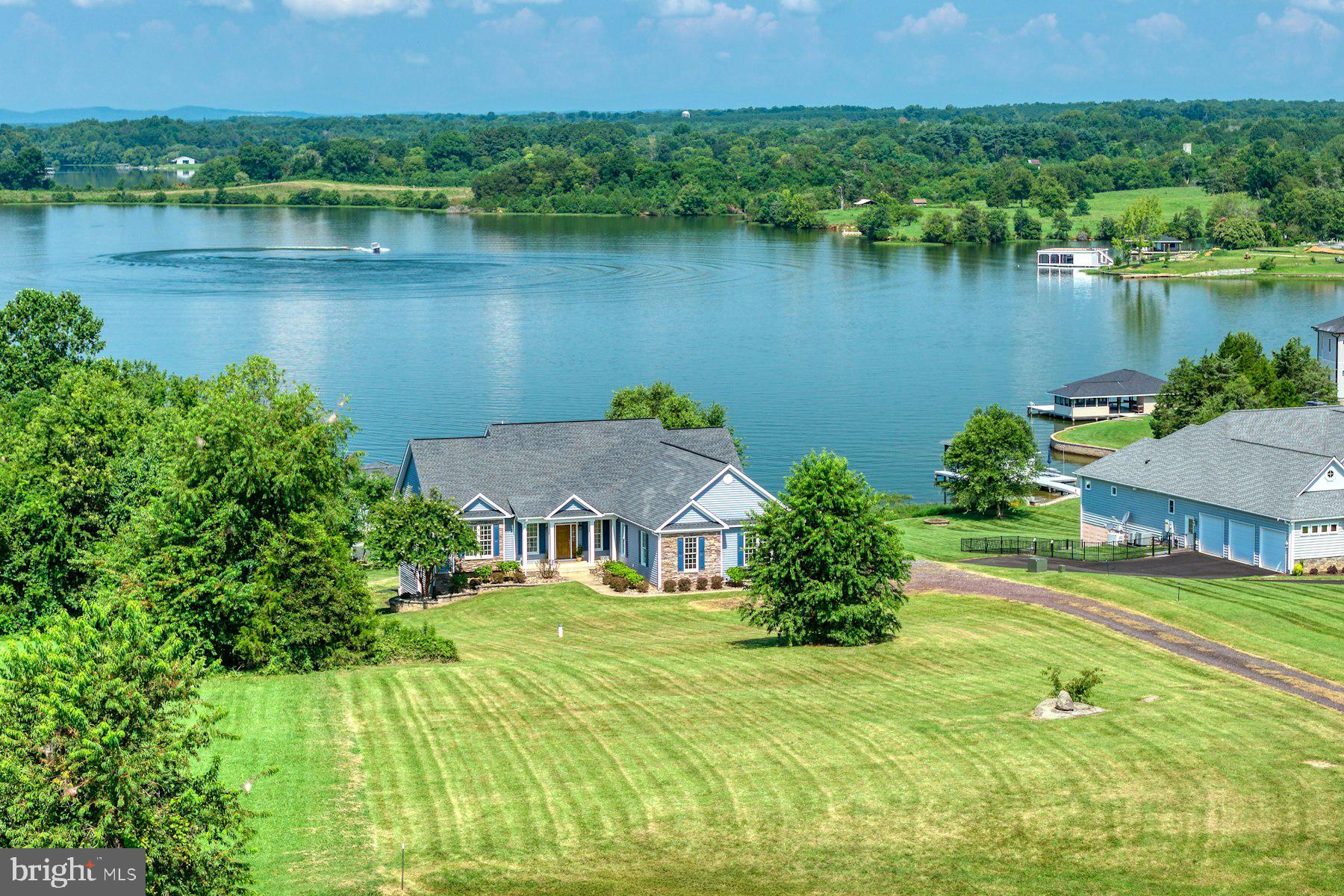 This exceptional custom-built home on Lake Anna’s sought-after public side is a rare blend of luxury, craftsmanship, and thoughtful design. Whether you're looking for a primary residence, a relaxing lakefront escape, or a high-end income-producing Airbnb, this property delivers on every level.
The open-concept main level features sweeping lake views, warm hardwood floors, and a striking custom sandstone hearth and stone fireplace. A gourmet kitchen is outfitted with top-of-the-line JennAir appliances, including a 36" induction cooktop, convection microwave, oven, and upgraded cabinetry with solid wood, soft-close doors and drawers. Tile finishes elevate every bathroom, and upgraded lighting adds elegance throughout the home. Views are endless and sunsets are amazing.

Unmatched Comfort & Energy Efficiency
*ADA-compliant doorways for accessibility
*2x6 framing construction with Rockwool R23 wall insulation and a Rockwool/Formaldehyde-free ceiling insulation combo totaling R61
*Rockwool Safe and Sound insulation in all interior walls and floors for superior noise reduction
*Top-tier Carrier Infinity Greenspeed Heat Pump (5-stage variable speed) for ultra-quiet, efficient climate control
*Zephyr Power Tempest I Pro Collection 36 in. Convertible Range Hood in Stainless Steel
*400-amp electrical service and Rinnai tankless hot water heater (9.4 GPM)

Premium Materials & Finishes
*Anderson 400 Series Low E4 windows throughout
*Rear-facing windows and patio doors feature Low E4 SmartSun glass that blocks 95% of UV rays for superior energy performance
*All interior doors are solid wood or solid-core with ball-bearing hinges, free of formaldehyde
*Honeycomb blinds throughout, with blackout options in all bedrooms
Spacious Living Inside & Out
*4 bedrooms, 4 full bathrooms 1 powder room, including an upgraded primary suite with a spa-like shower featuring a *Kohler thermostatic valve and dual controls
*Fully finished walkout basement with expansive lake views, two bedrooms, two bathrooms, built-in cabinetry, and a wet bar — perfect for guests or multi-generational living
*Oversized 27’ x 27’ fully insulated two-car garage with insulated 10’ x 8’ garage doors
*Azec and vinyl-wrapped rear deck ideal for lakeside lounging and entertaining
*Professionally installed irrigation system in the backyard (easily expandable to front yard)
*Oversized custom fire pit for evening gatherings under the stars

Dock Features
 This expansive 2,000 sq ft Trex dock offers the ultimate in lakeside living, built for durability, convenience, and entertainment.
* Equipped with electric and water for full functionality
*Finished with Azek-wrapped band boards for low-maintenance longevity
*Two boat slips, each with high-capacity lifts (7,000 lb and 10,000 lb)
*Custom Tiki Room with refrigerator — perfect for lakeside entertaining
*Large, secure storage room for all your gear and lake essentials
*Remote-controlled hurricane-rated shutter doors provide easy access and protection for the Tiki Room and storage
*Fully enclosed ceiling with integrated recessed lighting adds a clean, polished look
*Two swim ladders for convenient lake access

From the smart design and premium upgrades to the incredible lake views and dock, this home is a standout on Lake Anna.