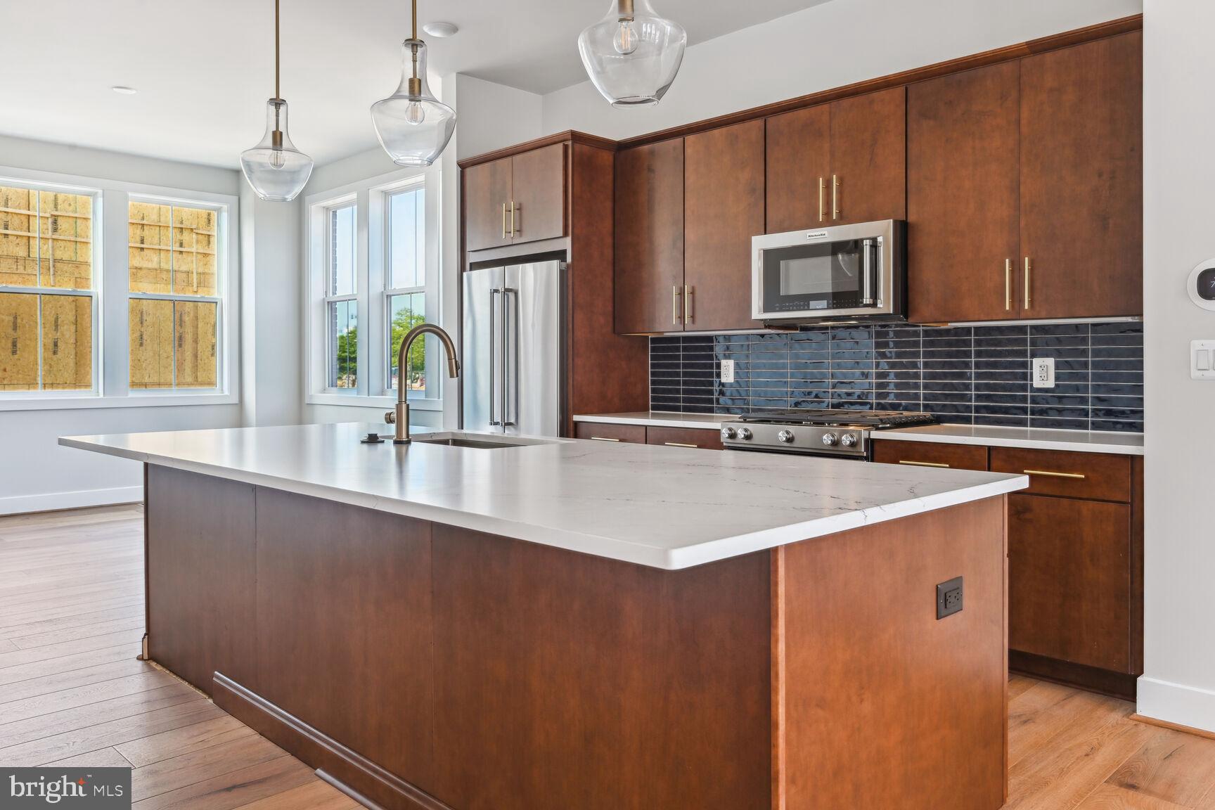 Step inside the open an airy main living level where you will find a Chef’s dream kitchen, light-filled dining room, and large great room that opens to the outdoor living.  The kitchen is complete with Ethereal Noctis quartz countertops, Sepia cabinets, KitchenAid appliances, and warm brass finishes. Upstairs boasts a luxe primary suite with huge walk-in closet and two secondary bedrooms.  The third floor features rooftop terrace, covered outdoor living, and a large loft that is the perfect flexible space.  A spacious open rec room completes the lower level.