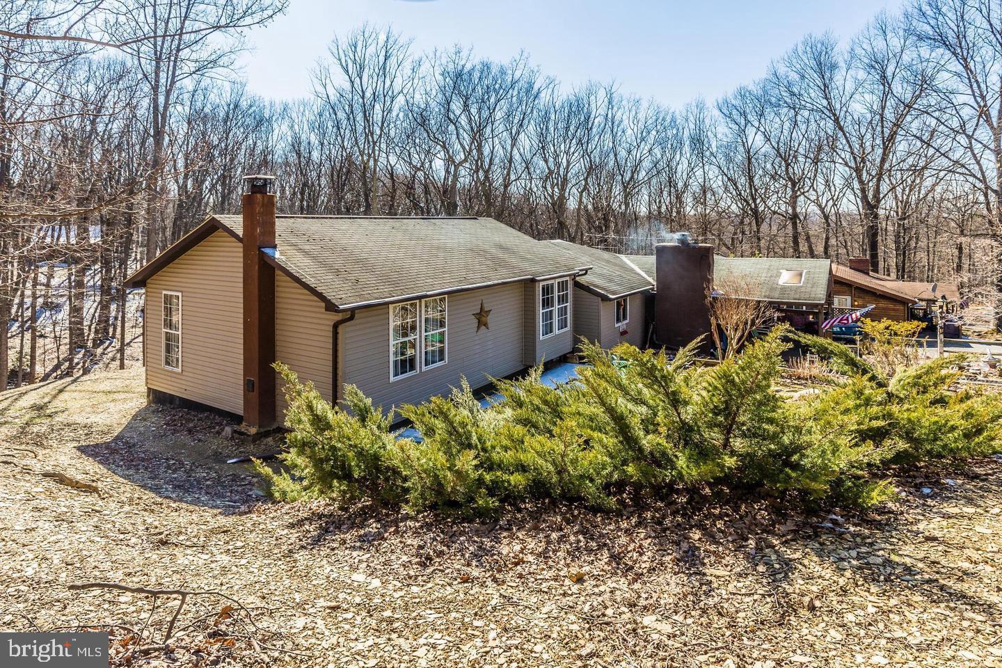 PRICE IMPROVEMENT- MOTIVATED SELLER- HOME CAN ONLY BE FINANCED CASH, CONVENTIONAL, OR REHAB LOAN. Welcome to 200 Revenoor Rd, Harpers Ferry, nestled in the peaceful Shannondale neighborhood! This charming log cabin-style home sits on just over an acre and includes two additional lots that may be buildable—buyer to verify. With two driveways, one featuring a carport, convenience and space abound. Inside, the 2-bedroom, 2-bath layout offers generously sized rooms, including a spacious primary suite with a large walk-in closet and a full bathroom. A cozy wood-burning stove adds warmth and character. The kitchen provides ample cabinet space, perfect for all your cooking and storage needs. Enjoy stunning mountain views from the inviting front porch, or relax in the sunroom and on the back deck. Located just minutes from the Shannondale Lake and the Shenandoah River, this home offers easy access to outdoor recreation while boasting wood floors, two fireplaces, and plenty of storage throughout. Don't miss this unique opportunity!