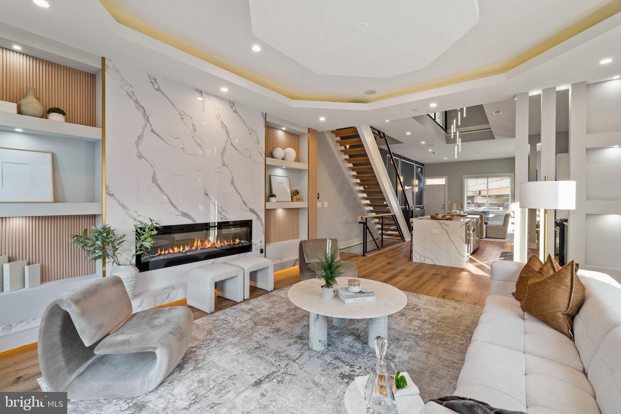 Experience next-level luxury living in this brand new Fishtown masterpiece. This architecturally striking townhome with 4200 square feet of living space, 20 feet wide, and within the coveted Adaire school catchment dont come arround very often.  Step inside to a dramatic first floor where the dining area flows into a showstopping chef’s kitchen featuring vaulted ceilings, high-end appliances, double oven, wine fridge, waterfall island, premium designer finishes, and a statement chandelier suspended from the second story is the kitchens focal point. The rear living room delivers a true cinematic vibe with its fireplace, stunning feature wall with custom surround shelving, and coffered ceilings with cove lighting.  One of the home’s standout features is the extra-large, professionally landscaped rear and side backyard. Thanks to its unique lot shape, the rear opens to an impressive 36 feet of width, offering a rare amount of outdoor space in the city plus two car driveway parking for unmatched convenience. The second level hosts two spacious bedrooms, each with its own en-suite bath, along with a hallway laundry room and linen closet. The entire third floor serves as a your luxury primary retreat, complete with two walk-in closets, an expansive bedroom with an fireplace and built-in shelving with LED lighting, overhead & pendant lighting  and a spa-inspired bath with a extra large walk-in shower, large soaking tub and double vanity. A flexible bonus room on this level makes the perfect home office, nursery, or dressing suite. The fully finished basement adds even more versatility with an entertainment room, a fourth bedroom, and a full bathroom, ideal for guests or extended living. Tech-forward features include a security system with exterior cameras and a Bluetooth-integrated audio system with speakers throughout. A top-floor wet bar with an additional beverage fridge leads to your private roof deck with sweeping skyline views, the ultimate backdrop for morning coffee or sunset gatherings. 10 year tax abatement and 1 year builders warranty included. A residence crafted with this level of scale, design, and intention is more than a home it's a statement piece for modern Fishtown living.