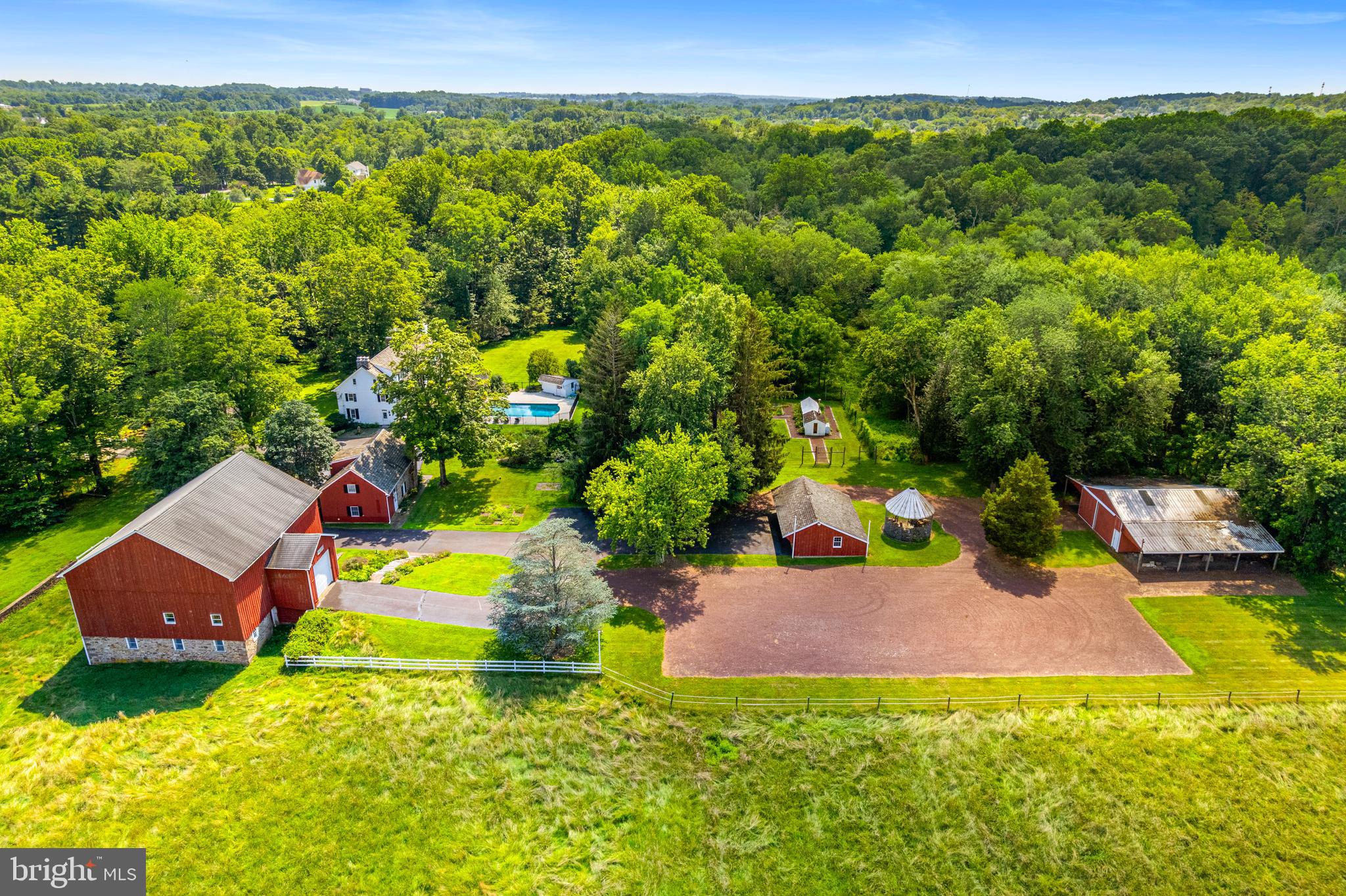 Gorgeous Bucks County Farmstead gracefully nestled on a scenic, tranquil backdrop of rolling country land that offers the utmost in privacy yet is convenient to everything. Over 20 acres of beautiful meadows, hayfields, open space, endless perennial gardens, rustic spring house with neighboring creek and more! This truly inspiring and lovingly preserved hobby farm offers a perfectly positioned main house, carriage house, large barn with stalls and gallery space, detached 3-car garage, pole barn and greenhouse.  The stately tree-lined drive is a precursor to the beauty that awaits. The antiquity and sustainable space in the stone farmhouse offer a glimpse into its 1700’s past while bestowing some modern touches although maintaining the historic charm. Features include 4 bedrooms, 3.5 baths, bonus third floor flex space which can be utilized as a studio or fitness space and partially finished lower-level ideal for a billiard/pub room. Abundant in character, this vintage beauty showcases skillfully crafted exterior and interior stonework along with deep windowsills, exposed beam ceilings, period hardware, cedar roof, 5 wood-burning fireplaces, wood floors and built-ins throughout. Relax outdoors on the covered back porch or lounge at the saltwater pool with convenient pool house highlighting a full bath while admiring the wildflowers and long distant meadow views with the sounds of nature all around. Guests can enjoy their own serenity in the eye-catching, spacious Carriage House featuring 3 bedrooms, 2 full baths, kitchen and living space adorned with wood beam accents and a sizeable picture window to admire the grounds. The lower portion of the classic Red Barn can easily host horses and other animals with multiple stalls while the upper portions are finished to accommodate a multitude of uses. In the past, this included an art studio and gallery, but any collector will delight in this space as well as the separate Pole Barn building.   So much to be discovered on this glorious compound bordering 50 acres of preserved land. Meander through your own nature preserve and hike on your own walking trails, grow your own vegetables, and raise farm animals while enjoying this hidden piece of paradise showcasing charm and cozy living quarters. The mural-like setting located just minutes from downtown Doylestown, exemplifies one of the finest properties in Bucks County with its traditional design and every amenity appreciated for today's lifestyle. *****The land has yet to be preserved. Opportunity for a Conservation Easement and Separately deeded 2 acre building lot can add even more value to this special property. Enjoy low property taxes under Act 319.