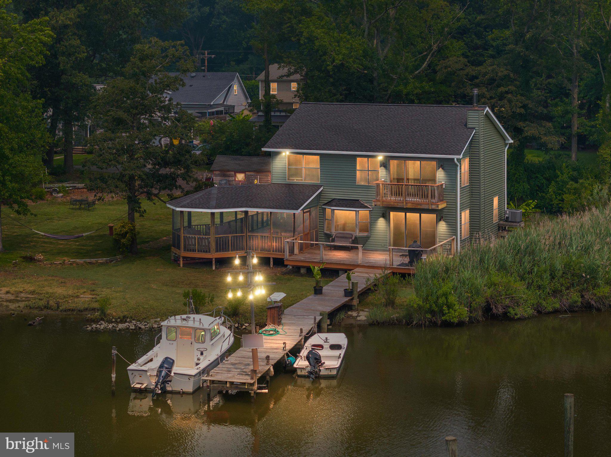 New roof & gutters installed last week! Welcome to your own private waterfront retreat nestled at the peaceful head of South Creek, where breathtaking views, abundant wildlife, and the ultimate Chesapeake Bay lifestyle come together. Perfectly positioned on a beautifully level lot, this exceptional property offers a private pier ideal for launching a kayak, canoe, paddleboard, or boat, while the nearby community marina provides access to deep-water slips for larger vessels. Residents also enjoy access to the community beach, making every day feel like a vacation. An added bonus is the inclusion of the adjacent Lots 17 & 18 (4907 Thomas Drive), providing additional privacy, flexibility, and future possibilities. Step inside to discover a bright, open floor plan designed to maximize both the water views and natural light. The spacious kitchen features a center island, ample cabinetry, and a sunny breakfast area highlighted by a large picture window overlooking the creek—an unforgettable place to enjoy your morning coffee. The adjoining living room offers the warmth and charm of a wood-burning stove along with sliding glass doors leading to the expansive wraparound screened porch, creating the perfect space for indoor-outdoor entertaining or simply relaxing while watching osprey, herons, and other local wildlife. Upstairs, all three bedrooms are thoughtfully situated, including a spacious primary suite that serves as a true waterfront sanctuary. Wake up each morning to panoramic water views from your private balcony, then unwind in the en-suite bath featuring a walk-in closet and plenty of room to recharge after a day on the water. The additional bedrooms are generously sized, with one also enjoying beautiful water views, and are served by a second full bathroom on the upper level. This home has been thoughtfully updated for peace of mind and long-term enjoyment. Recent improvements include a brand-new roof (2026), renovated Tigerwood deck, and a professionally encapsulated crawlspace complete with a dehumidification system. If you’ve been dreaming of a waterfront lifestyle that combines privacy, natural beauty, and everyday comfort, this is a rare opportunity to own a special piece of Southern Anne Arundel County. Whether you’re boating, crabbing, kayaking, entertaining on the screened porch, or simply enjoying the peaceful creek views, you’ll quickly understand why this location is so special.