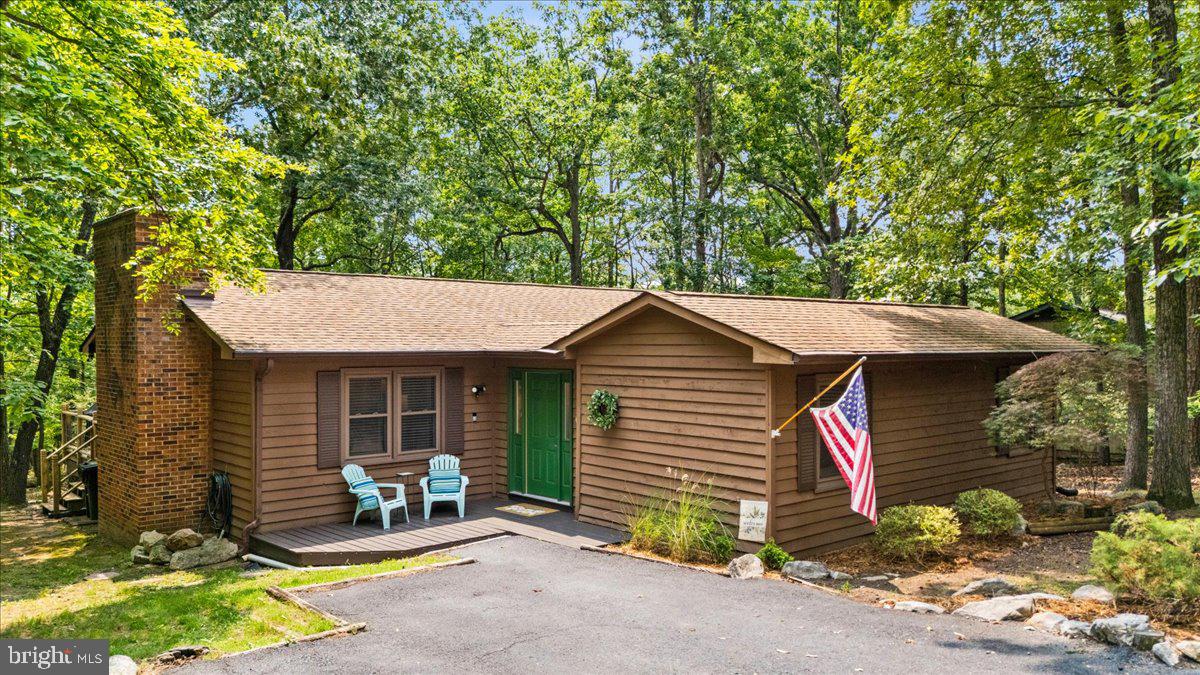 Conveniently located to everything in Massanutten! Single-level home on wooded lot with large rear wood deck and screened porch, which is also accessed from primary bedroom with en suite bath. Living room features decorative brick wall and hearth with wood-burning stove, steps from kitchen and dining room. Separate family room gives extra living space for kids or groups, with convenient access to 4th bedroom. Hot tub is uniquely situated in private enclosed courtyard deck in center of home. Fresh interior paint throughout (2026), rebuilt hot tub (2026). New Microwave (2026), new water heater and washer & dryer (2022), new decking (2021). Turnkey rental with established rental history being sold completely furnished. Located in the Massanutten community, a four-season resort with skiing, golf, hiking, mountain biking, indoor/outdoor waterpark, dining and many other amenities.