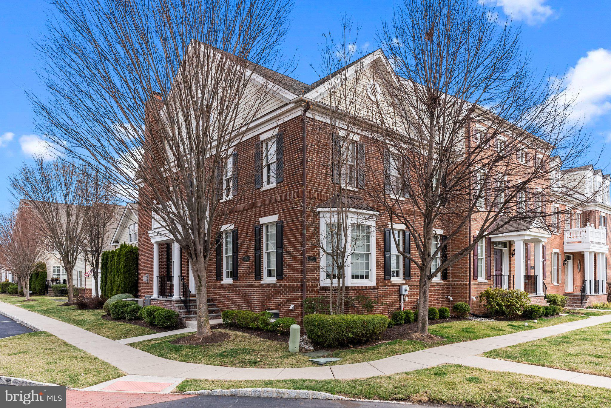 This pristine, upgraded Sequoia model in Newtown Walk is situated in a superior location, and offers an entry that enhances the feel and look of a single-family home. Beautifully appointed with four levels of living space and totals 5000 square feet, this stunning residence features an open floor plan and sun-filled rooms that provide an abundance of natural light. Gleaming hardwood floors, custom millwork, and a beautiful deck are just a few of the impressive details. The welcoming foyer leads to a formal living and dining room, an inviting family room boasting a gorgeous gas fireplace and access to the lovely deck. The upgraded and customized kitchen is a chef's dream, complete with granite countertops, stainless steel appliances, and an expanded island with a custom bar area. The private deck offers a perfect oasis for summer entertainment. The finished loft above the garage provides versatile flex space, ideal as a beautiful office. The second level highlights a lovely primary suite with an elegant bath, two additional bright and airy bedrooms, a full hall bath, and a convenient laundry room. The third level is finished as a full suite with a private bath, adding additional comfort and privacy. The finished basement is a must-see, featuring Brazilian hardwood floors, a custom bar for entertaining, and ample space for playing or relaxing. An additional bedroom and full bath complete this level. The home's brick and Hardie Plank exterior is enhanced by lush landscaping and a full irrigation system. Located in the desirable Newtown Walk community, just minutes from exciting Newtown Boro, residents can walk to shops and restaurants. The Roberts Ridge Park is a 22.8-acre park located adjacent to the community. It is home to a large inclusive playground, restrooms, picnic tables, and benches making a visit to the park enjoyable. The Newtown Trail also traverses Roberts Ridge Park allowing walkers to access Newtown Borough, Silver Lake Park, Carl Sedia/Chandler Fields, and Tyler State Park. Convenient access to trains and major roadways makes travel to Philadelphia, New York, and Princeton a breeze. Only 20 minutes to Mercer Airport! This exceptional home offers comfort and style in every season—Come visit, and you will want to make it yours!