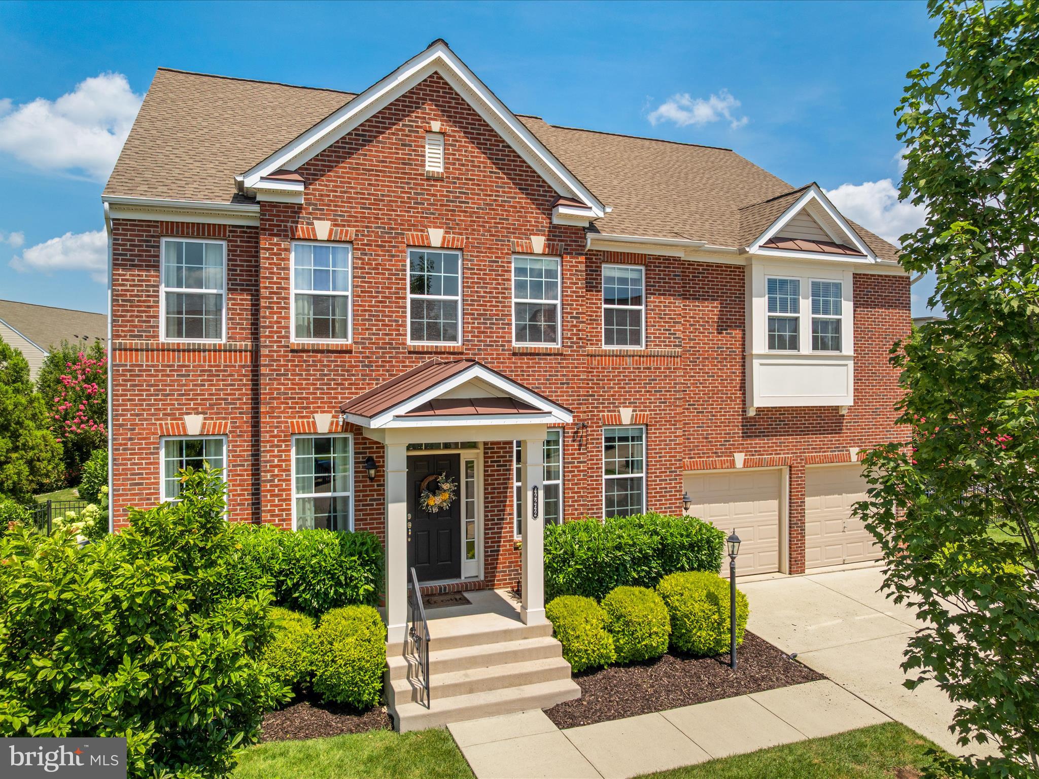Open House Saturday August 2 from 11 am - 2 pm.
Discover this magnificent brick-front residence spanning over 5,200 finished square feet with 5 bedrooms and 4.5 bathrooms. This exceptional home occupies one of Brambleton's most expansive cul-de-sac lots, perfectly positioned mere steps from the vibrant Brambleton Town Center. Every detail has been meticulously crafted, from the dramatic two-story entry leading to the elegant living and formal dining rooms adorned with wainscoting and crown molding, to the distinctive powder room featuring a trough sink and custom wallpaper. The heart of the home is a sprawling open-concept kitchen, showcasing an extended island, under-cabinet lighting, quartz countertops, a subway tile backsplash, high-end stainless steel appliances including double ovens and a gas range, and a walk-in pantry with custom shelving. This culinary haven seamlessly connects to a large family room with a cozy gas fireplace and a bright breakfast area. A generously sized main-level office provides the perfect workspace, complete with custom 9-foot built-in bookcases and a desk. The backyard is a true showstopper: a private outdoor oasis featuring a raised, covered flagstone patio, a heated saltwater pool with a captivating waterfall hot tub and diving board, a gas fire pit, and a spacious sun deck. An incredible outdoor kitchen and bar, equipped with granite countertops, a gas grill, and a refrigerator, completes this entertainer's paradise. Custom landscaping maximizes privacy, creating an unparalleled retreat. The upper level offers a serene primary bedroom suite with a sitting area, a luxurious primary bathroom featuring dual vanities, a walk-in shower, and an expansive walk-in closet with a custom system. Three additional upstairs bedrooms include a convenient Jack and Jill bathroom and a private en suite, all boasting generous walk-in closets. The walk-up basement expands the living space with a large rec room, a pre-wired media room, a fifth bedroom, and a full bathroom. Residents of award-winning Brambleton enjoy access to miles of walking trails, basketball and tennis courts, community pools, and parks, all conveniently accessible by foot, bike, or car.  See virtual tour for all room dimensions.