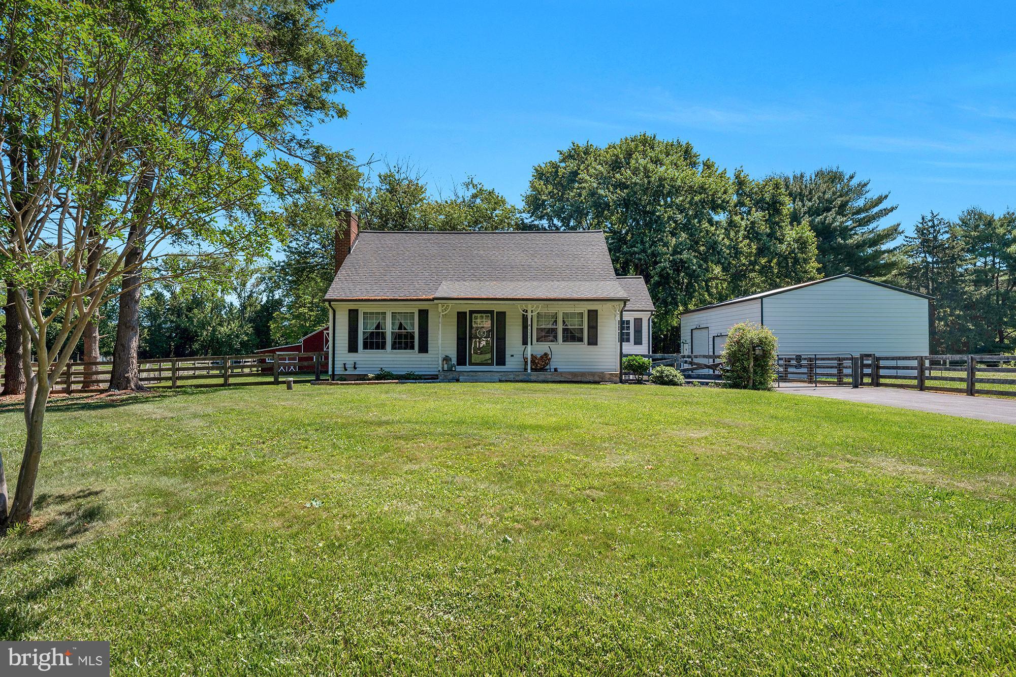 OPEN HOUSE SATURDAY (6/20) FROM 11AM-1PM!! Adorable, well thought out and excellently maintained mini-farmette in Southern Westminster PACKED with amenities! The cute, homey, and functional 3BR/2BA cape cod has a newer, roof, siding, and gutters for decades of easy maintenance living ahead. The huge 3 bay detached garage, freshly painted 30x40 back deck, hot tub, and 2 stall barn with overhang/run-in, riding area and multiple fenced paddocks cover all the bases for outdoor activities, hobbies, small business pursuits and keeping all four legged and four wheeled family members happy! The inside of the home is charming and bright with hardwood flooring spanning almost every room of the home. The living room features a cozy wood stove and big windows. The rear of the home contains a bedroom or office, updated full bath with tub/shower combo, and updated kitchen. There is a large mud room with LVP flooring off the kitchen that leads directly to the back deck with steps down to the newly sealed driveway and hot tub. The entire property is fenced, and a gate across the driveway provides added peace of mind. The first floor also contains a bright dining room to the front of the home, and a pantry. Upstairs, find two large bedrooms, one with walk-in closet, and another full bath with shower/tub combo. Mini-splits provide personalized temperature control year round and efficiency. The full basement is unfinished and perfect for additional storage, or finish in in the future for additional living space. 
Outside, the quaint 2-stall barn has dutch doors, water, electric, and run-in off the back, and plenty of storage for hay and equipment. The outdoor riding arena is equipped with LED lighting perfect for evening rides! There are multiple fenced grass paddocks, and horses ARE allowed on this property. The 3-bay detached garage is only a few years old, and is a car enthusiast's dream. It has 100-amp electric service, two 9’ and one 10’ doors. Lifts are negotiable with acceptable offer! This is a rare opportunity to own such a functional, well appointed property in this location - what a gem!