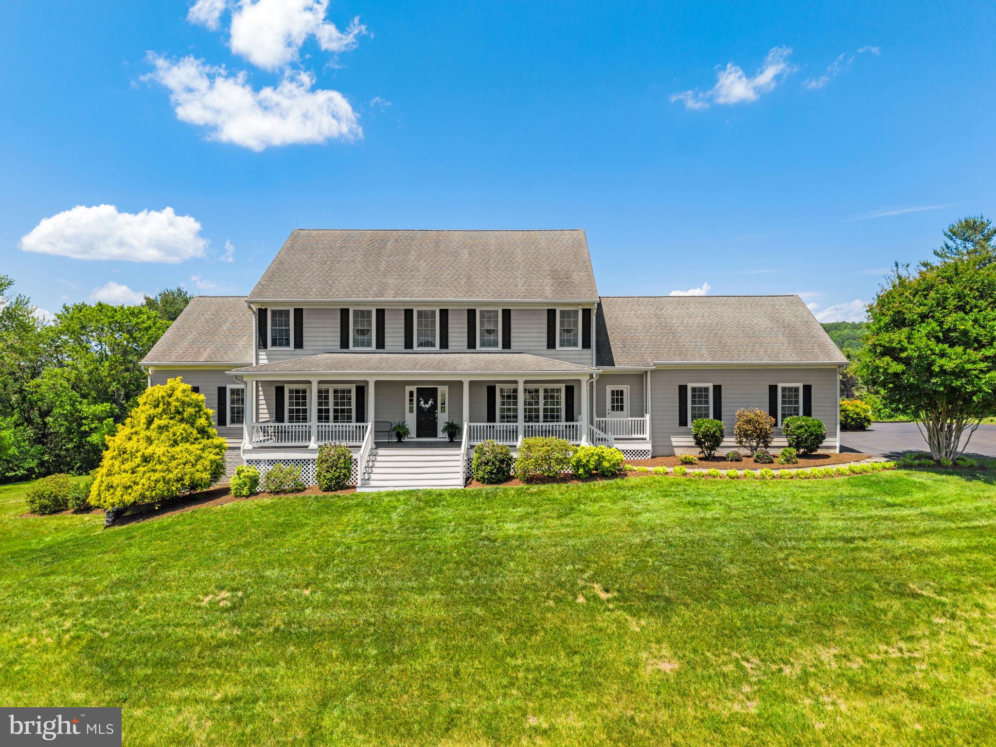 Nestled on a picturesque 4-acre parcel with breathtaking views in every direction, this custom-built home offers the perfect balance of privacy, peaceful surroundings, and everyday convenience, just minutes to Warrenton and Haymarket. Thoughtfully designed for versatility and long-term living, this exceptional property features 6BD/5BA and dual Primary Suites on the Main and Upper Levels. Conveniently located near Routes 29, 55, and I-66, enjoy easy access to dining, shopping, medical facilities, outdoor recreation, and nearby wineries. The paved driveway and stone walkway guide you to the inviting covered Front Porch overlooking panoramic pasture views. Inside, the welcoming Foyer showcases rich hardwood flooring, updated lighting ('26), and hardwood stairs to the Upper Level. Formal Living and Dining Rooms flank the Foyer and feature custom moldings, gleaming hardwood floors, and expansive sunlit windows. The magnificent Gourmet Kitchen is truly the heart of the home, featuring a commanding 12-foot live-edge island, new quartz countertops ('26), modern subway tile backsplash ('26), abundant 42" stacked cabinetry, huge walk-in pantry, hardwood flooring, and appliances including a 5-burner Miele cooktop with new range hood ('26), refrigerator ('26), built-in microwave ('26), Bosch dishwasher, and Miele double convection wall ovens. The Kitchen opens seamlessly to the Breakfast Room with access to the deck and backyard retreat through a sliding glass door ('12). Nearby are the Mud Room with new LVT flooring ('26), Laundry Room with ample cabinets, new LVT flooring ('26), laundry chute, balcony access, washer/dryer (convey), refreshed Full Bath ('26) with quartz counters and updated LVT flooring, and access to the oversized 2-car Garage. The Family Room features hardwood flooring, a cozy gas fireplace, wet bar with new quartz ('26), deck access, and connects to the Main Level Bedroom Suite, ideal for main level living, guests, or added versatility. The Main Level Suite includes a walk-in closet and newly updated Ensuite Bath ('26) with double vanity with quartz counters, separate shower with tile surround and built-in niche, and upgraded LVT flooring. Upstairs, brand-new neutral carpet extends throughout ('26). The spacious Primary Suite features an oversized walk-in closet, versatile Sitting Room/Flex Space, and fully renovated spa-inspired Primary Bath ('26) with double vanity with quartz counters, tile flooring, soaking tub, and separate shower with tile surround and built-in niche. Bedroom 2 offers dual closets and recessed lighting, while Bedrooms 3-5 are generous in size and feature ceiling fans, large closets, and sunlit windows. The Hall Bath includes a refreshed vanity with quartz ('26), newer LVP flooring, and tub/shower area. The Fully Finished Walk-Out Lower Level provides exceptional flexibility with a Rec Room featuring a gas fireplace, refreshed Full Bath ('26) featuring a vanity with new quartz ('26) and tub/shower, spacious Game Room with new luxury vinyl plank flooring ('26) and sliding glass door ('15) to patio, oversized Den ideal for a Bedroom, Theater, or Exercise Room, plus a Storage/Utility Room. Additional updates include fresh interior paint on all levels ('26), upgraded lighting throughout ('26), updated Upper Level HVAC ('21), professionally cleaned lower level carpet ('26), oversized Garage with high ceiling, hook-up for future generator (if desired), replaced roof boots ('25), exterior power washed and painted ('26), built-in storage beneath Front Porch ('26), well pump ('19), and more!