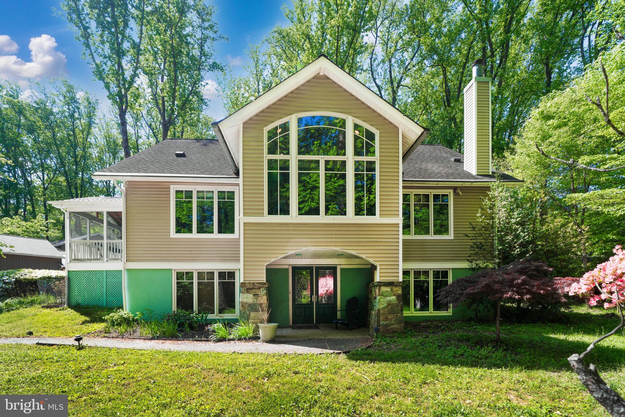 Striking contemporary home on a beautifully wooded lot offering exceptional privacy and architectural character. This 5‑bedroom, 3.5‑bath residence features dramatic vaulted ceilings, skylights, and a bright, open layout designed for both comfortable living and flexible use.

The main level includes expansive living and entertaining spaces: great room with fireplace, sunroom with heated floors, screened porch, dining area, and a chef’s kitchen with white cabinetry, granite countertops, center island with breakfast bar, double oven, and built‑in microwave. The main‑level owner’s suite provides a private retreat with a walk‑in closet with organizers and a spa‑style bath with dual vanities, large shower, and oversized jetted tub surrounded by windows.

A unique street‑side entrance creates an ideal setup for a home office, studio, or client‑facing professional space. Heated floors extend through the office, waiting room, sunroom, and primary bath. Surround‑sound speakers are installed in the front room, patio, sunroom, and primary bedroom.

The upper and lower levels offer four additional bedrooms, perfect for guests, offices, or multi‑purpose living. The walk‑out lower level includes a finished recreation room with wet bar and access to the rear yard.

Outdoor features include raised garden beds, fire pit, patio fountain, and a charming chicken coop (hens negotiable). Seasonal plantings add color throughout the year.

Prime location within walking distance to Potomac Village and directly on the bike path to Great Falls Park. Situated in a top‑rated school district and offering a rare combination of lifestyle, convenience, and versatility.