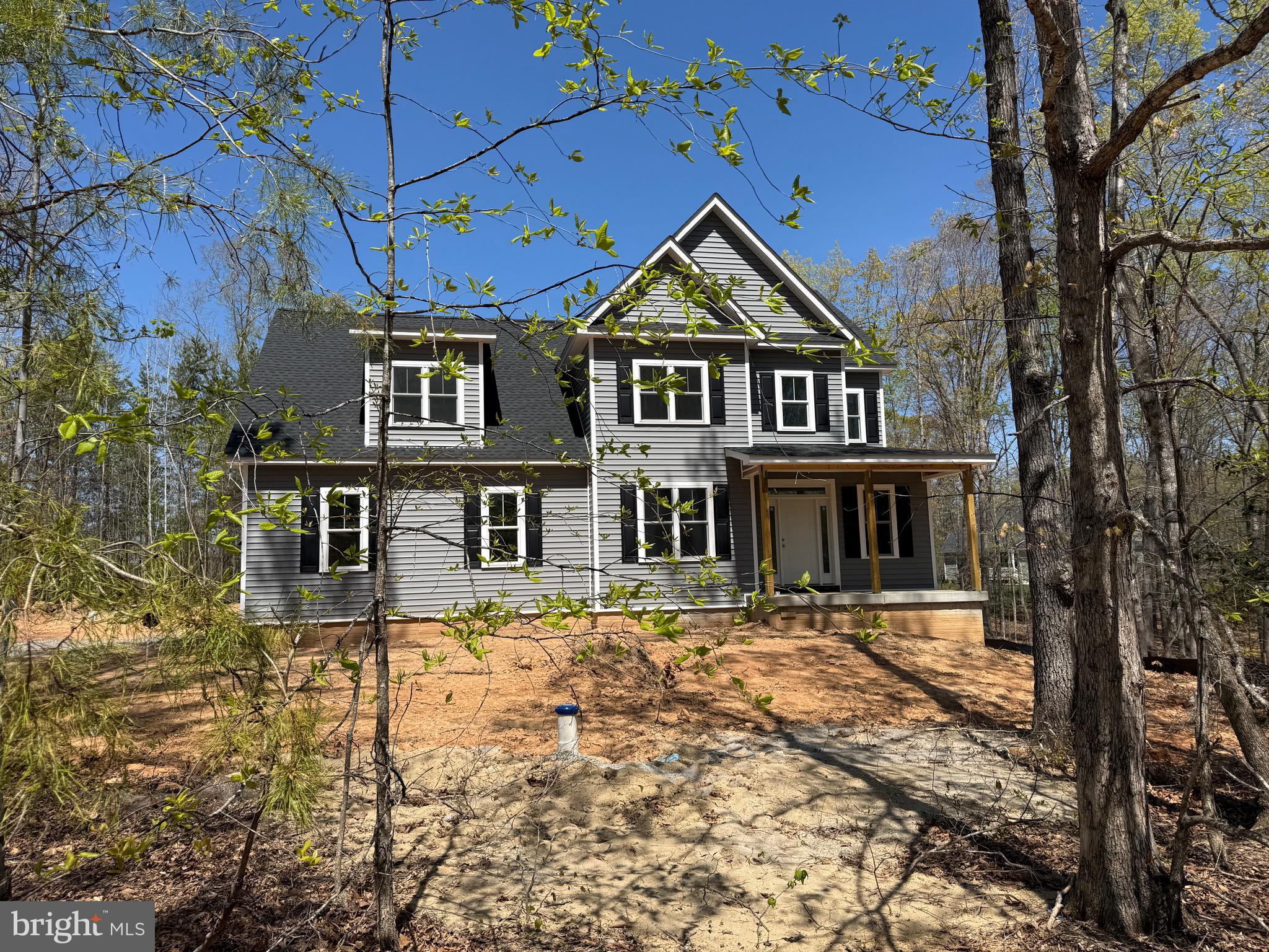Nestled in the serene enclave of Noah's Landing, this exquisite New Construction home is a testament to resort style living, set to be completed Spring 2026. With a stunning Colonial architectural style and crafted from high-quality materials, this residence promises both elegance and durability. Step inside to discover a thoughtfully designed interior that exudes warmth and sophistication. The open floor plan seamlessly connects the family room, adorned with a cozy gas fireplace, to the spacious kitchen, making it an ideal space for entertaining. The kitchen is a chef's dream, featuring upgraded countertops, stainless steel appliances, and a spacious island that invites culinary creativity. Enjoy casual meals or host formal dinners in the dedicated dining space. This home boasts five generously sized bedrooms, including a main level primary suite with a walk-in closet that offers a private retreat with a luxurious soaking tub and a walk-in shower in the en-suite bathroom. A second primary bedroom suite located upstairs with an oversized walk-in closet and private full bath.  The additional 3 upstairs bedrooms are designed with comfort in mind, featuring plush carpeting and ample closet space, ensuring everyone has their own sanctuary. A full hallway bathroom services these additional bedrooms.  The property is designed for modern living, with convenient main floor laundry/mud room  and a pantry for additional storage. The attention to detail is evident throughout, from the elegant ceramic tile flooring in the bathrooms to the inviting luxury vinyl plank in the common areas and main level primary bedroom suite. Outside, the allure continues with expansive rear deck and front covered porch that provide the perfect setting for outdoor gatherings or quiet moments of reflection. The nearly one-acre lot offers private access to Lake Anna, where you can indulge in a variety of water activities, including boating, fishing, and swimming. The private beach and access for personal watercraft enhance the exclusive lifestyle this property offers. With an oversized side-entry garage and ample driveway space, parking is never a concern. This home is not just a residence; it's a lifestyle choice that combines luxury, comfort, and the beauty of nature. Experience the tranquility of lakeside living while enjoying the modern conveniences of a brand-new home. Embrace the opportunity to make this dream home your own and create lasting memories in a setting that truly feels like paradise.