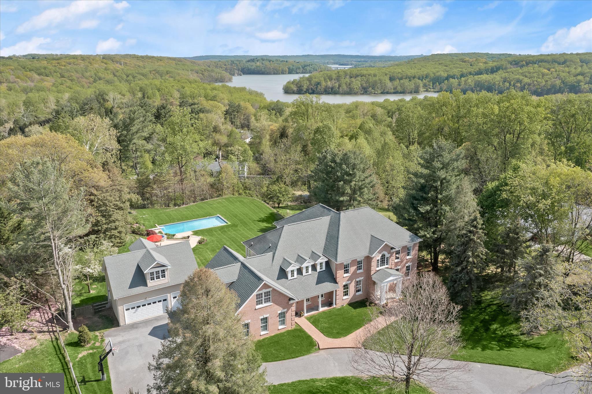 *******RARE RESERVOIR VIEWS - LIFESTYLE OPTIONS - IMMACULATE INSIDE AND OUT********
Nestled on a private road in the exclusive Summer Hill enclave, this exceptional custom home offers over an acre of serene living with breathtaking, unobstructed views of Loch Raven Reservoir—an incredibly rare find. Featuring 4 spacious ensuite bedrooms, 4 full and 2 half baths, and nearly 5,000 square feet of thoughtfully designed living space, this residence blends elegance with modern comfort.

The main level showcases hardwood floors throughout, a grand marble foyer, formal living and dining rooms, a private study with custom built-ins, and a stunning family room with gas fireplace, wet bar, full ice maker, and three atrium doors opening to a tiered deck overlooking the serene reservoir. The updated kitchen boasts new quartz countertops (2026), double wall ovens, gas cooktop, dual dishwasher drawers, and a bright breakfast area with deck access.
Upstairs, the luxurious primary suite features a tray ceiling, private balcony, sitting room, dressing area with multiple closets, and a beautifully updated spa bath with heated marble floors. An attached, fully finished bonus / flex room above the garage offers lifestyle options to the primary suite. Endless options to consider include a private den, study, hobby room or nursery. Three additional en-suite bedrooms complete the upper level.  The walk-out lower level offers 11’ ceilings, three atrium doors, and is plumbed for a full bath—ready for your customization.

Outdoor living is unmatched with a heated in-ground pool with auto cover, bluestone hardscaping and tiered gardens that wrap a sumptuous poolside sun patio and spa with glistening designer tile. Multiple decks are stacked in Southern stye and designed to maximize the stunning views, whilst an irrigation system keeps things lush. A thoughtfully designed garage addition adds 3 bays for a total of six garage bays. Forward thinking provides more flexibility over the second garage that is plumbed and ready to finish a second bonus flex space.   Amenities at every turn include a whole-house generator, central vacuum, water filtration system, and propane service for multiple utilities.
This is truly a rare opportunity to own a private retreat with unmatched views and exceptional amenities—just minutes from everyday conveniences.
