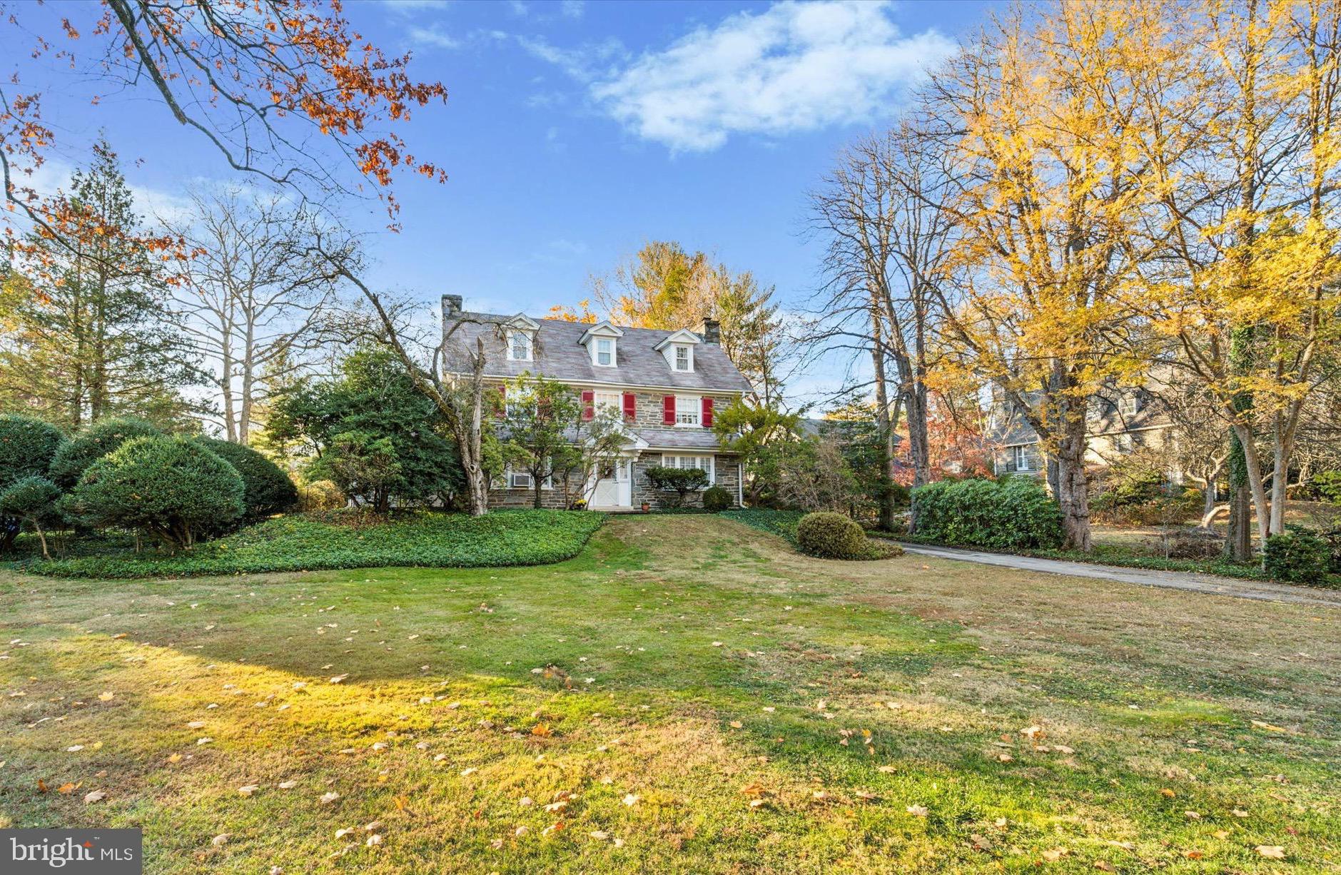 Welcome to an exceptional home that has been loved by the current owners for almost 60 years.
Sitting elegantly amongst mature trees, green lawns and manicured gardens in this highly desirable neighborhood, this stunning three-story, Stone Colonial masterfully blends classic charm with comfortable living. 
A wide brick walkway invites you up to the front door, hinting at the beauty within. Upon entering, you’re greeted by height, light and space with an open center hall and a grand staircase that immediately captures the essence of timeless elegance. 
Grand windows fill each room with natural light, while deep-set windowsills and hard wood floors add warmth and character throughout.
The first floor boasts a formal living room with a striking picture window overlooking a large patio, in-ground pool and expansive back yard. Here you can sit for hours on the window seat and view nature’s spectacular show which is your own private oasis away from the hustle and bustle. A beautifully appointed fireplace and built-in bookshelves make this room perfect for both quiet evenings and entertaining guests. 
The formal dining room, also complete with elegant fireplace and built-in cabinetry is an inviting setting for formal or casual dinners, not to mention lively celebrations. 
Off the living room enter a sun-soaked den with a third and impressive, stone fireplace, rows of sill to ceiling windows and an exit to the rear patio, providing a more informal, relaxed space to enjoy family time and perhaps, pop out for a swim in the pool. 
The walk up the stairs to the first landing showcasing your expansive backyard through the great picture window convinces you each time you arrive there, this home is truly a magical place.
Take three more steps to find three spacious bedrooms and two full bathrooms on the second floor. The primary bedroom is as grand as the living room with beautiful light, space and privacy from the other rooms. It boasts a walk-in closet and an ensuite bath with a full tub/shower. 
On the opposite side of the house is a large room with perfect light which can be a bedroom, office or big dressing room. 
A third large and private bedroom with full bath with tub/shower, a deep inset cedar closet and a spacious linen closet with built-in shelving complete to this floor.
Ascend the open staircase to the third floor, where three additional
bedrooms await, oﬀering flexibility for family, guests, or a private home
oﬃce.  A full hall bathroom with a classic clawfoot tub along with a generous storage room, providing ample space for both comfort and organization complete this floor. 
The kitchen overlooks the patio and gardens with windowsills basking in warm light where plants thrive and windows to the ceiling offer wide views of your backyard. 
The most active room in the house offers a gas stove, dishwasher and plenty of cabinets and prep space. There is also a walk-in butlers pantry featuring wall to wall cabinets for plenty of storage, a powder room and a mud room with an exit to the driveway.
Outside, the expansive grounds oﬀer beauty, peace and tranquility. The mature landscaped yard features a lovely patio with brick walls, colorful gardens, a sparkling in-ground pool complete with pool house offering 2 changing rooms and bathroom - perfect for summer relaxation or entertaining.
Additional features of this home include a full basement with laundry area, a finished room and plenty of storage room. There is a two car detached garage with a finished loft space above- ideal for a home-oﬃce, yoga or creative studio. 
Situated within the award-winning Lower Merion School District, 402 Penn Road combines elegant living with ultimate convenience