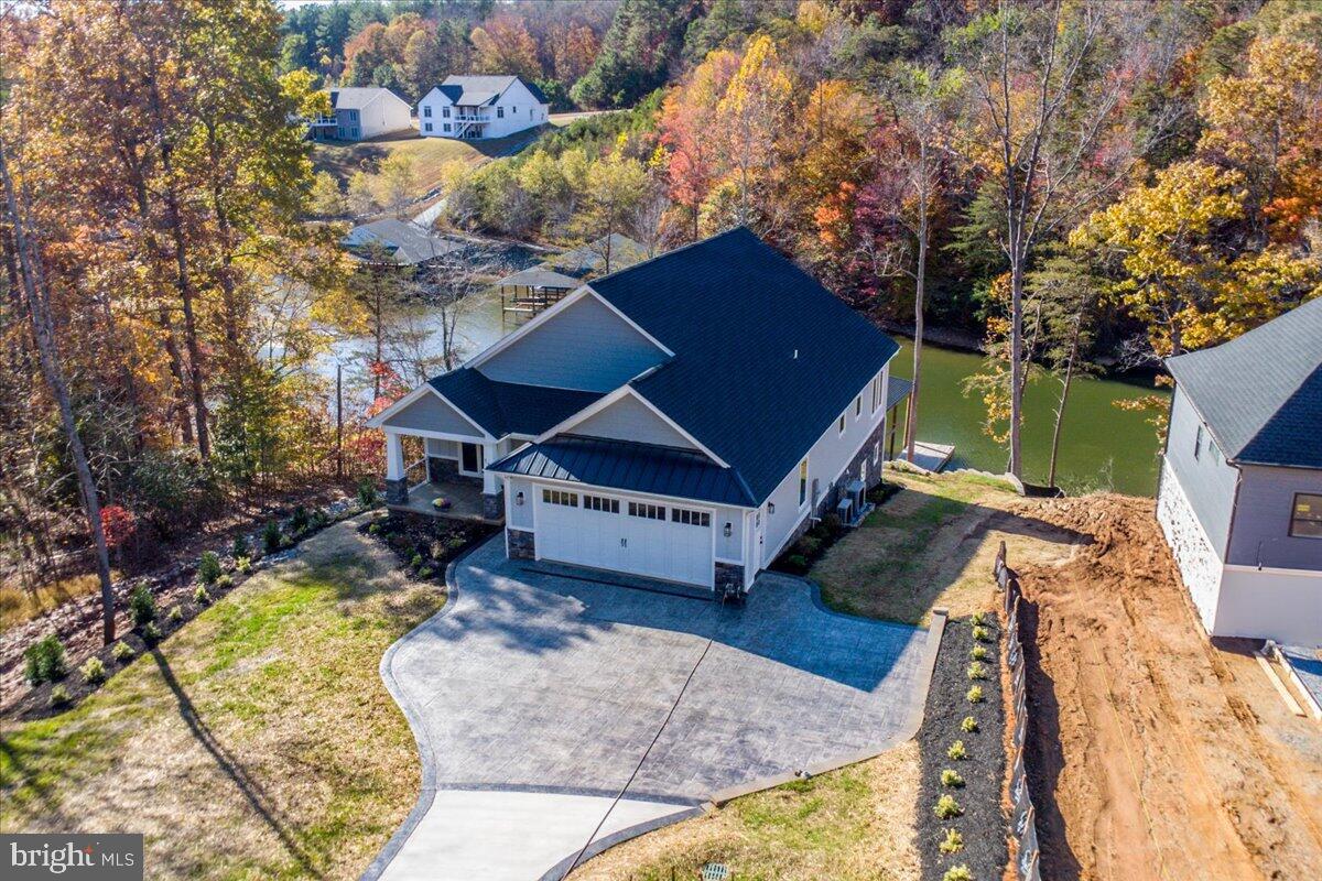 **Luxury Waterfront Living on Smith Mountain Lake** Discover the perfect blend of craftsmanship, comfort, and lakeside luxury in this stunning new waterfront home on Smith Mountain Lake. Offering spacious 4,400-square-foot living space with four bedrooms and four and a half baths, this property is designed for exceptional living and entertaining. Step inside to find vaulted ceilings, Craftsman-style doors, and LVP flooring throughout. The living room features a gas log fireplace, while the gourmet kitchen impresses with granite countertops, Bosch appliances, a gas cooktop with custom hood, pot filler, walk oven, built in microwave and an oversized pantry. The home also includes a laundry room, office/ movie room for relaxing nights in.

Retreat to one of two custom tile walk-in showers with custom glass doors and pebble floors, or enjoy the outdoors on one of two composite decks under a custom tongue-and-groove vaulted ceiling with fan. Pella windows frame lake views in three directions, and 12-foot sliding doors on both levels seamlessly blend indoor and outdoor living.

Additional features include:

* Gas log fireplace hookup on the lower level and a second kitchen downstairs
* Two separate water manifolds, each with its own water heater
* Mini split 2-zone HVAC for energy efficiency
* 24x24 garage with 18-foot garage door with expansive floored storage above
* Stamped concrete driveway, LP siding, and stone veneer exterior
* Extensive landscaping with public water and sewer

The property also includes an exceptional **boat dock** complete with a covered slip, lounge area, bar, storage room, and oversized floater, perfect for enjoying Smith Mountain Lake to the fullest.

Located just minutes from Westlake shopping and Halesford Bridge, this one-of-a-kind home offers the ultimate in lakefront luxury and convenience.

**Experience Smith Mountain Lake living at its finest, schedule your private tour today!