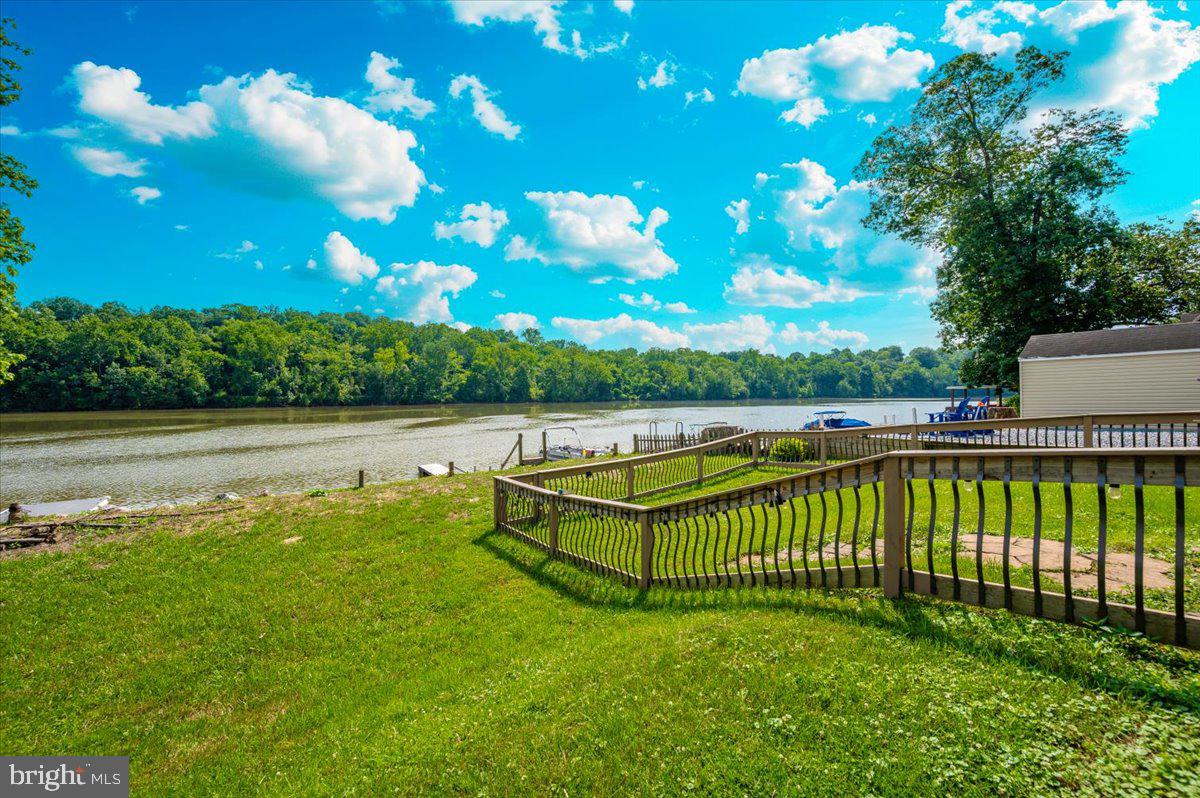 Waterfront in River Bend!!! ( The camper has been removed and does not convey) This is your chance to own a piece of serenity.  Located in gated River Bend seasonal campground (from April 1st until November 1).   Patio furniture/bar and a Blackstone grill that all convey!!! This property has not flooded  up to the Pavilion 50+ years.
Beautiful landscaping , partially fenced yard, enormous 24x45 pavilion with sun shades, and a stamped concrete patio.  Fence is removable if needed. This truly is a must see!!!   Annual dues are approx. $1900 annually and they include water, trash, electric, and sewer pump out, use of 3 pools, mini golf, basketball courts, tennis and horseshoes . Community also has a camp store, laundry mat, church fellowship , and a nice restaurant/bar. There are several large pavilions which are available for rent for special events as well. Don't let this one pass you by!!!