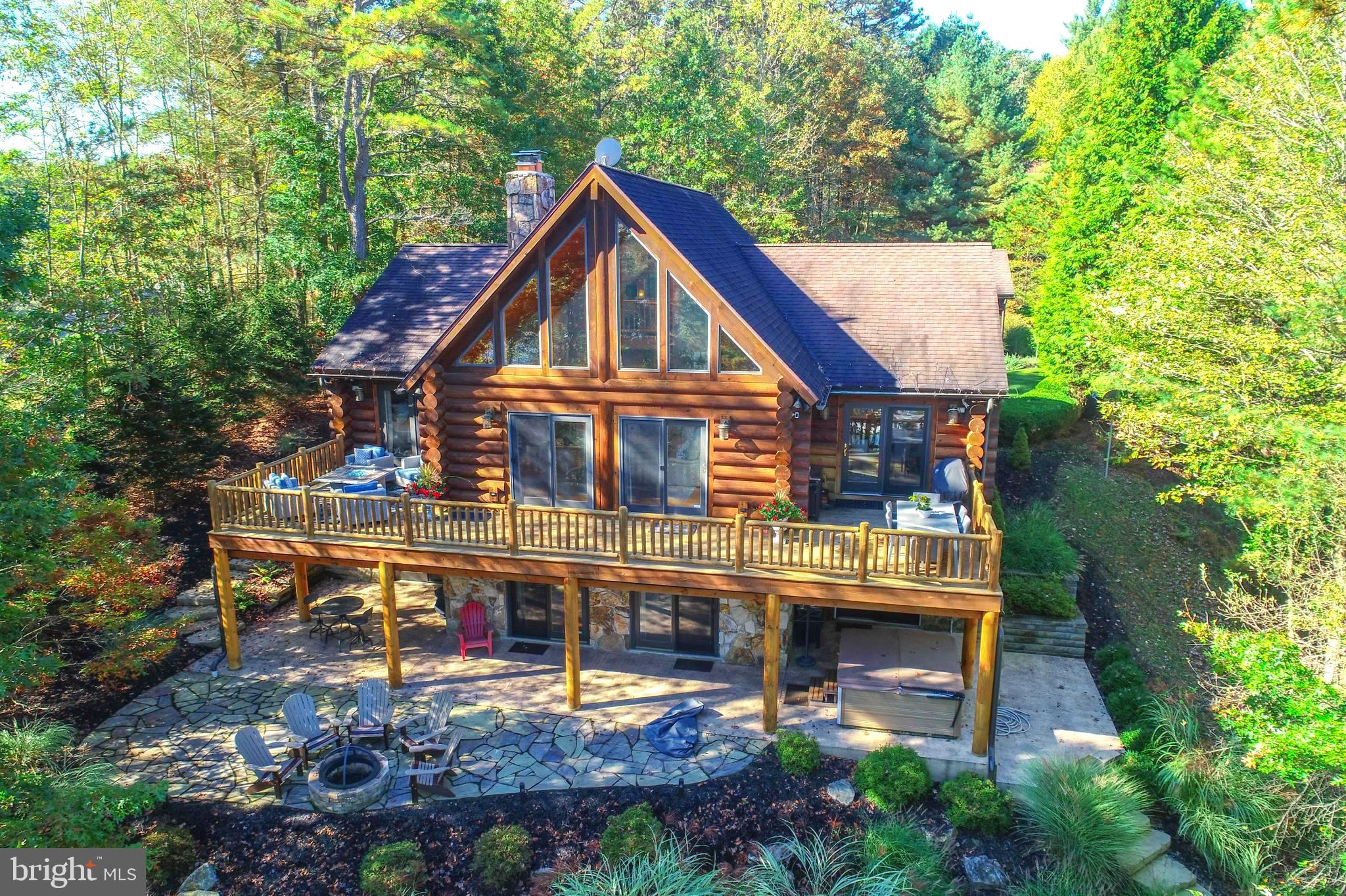 An extraordinary lakefront sanctuary awaits on this pristine 2-acre parcel representing a rare opportunity within  Deep Creek Lake's coveted Pergin Farm. This incomparable custom residence captures the essence of  mountain lake lifestyle living  with vaulted ceilings, dramatic native stone fireplaces, and territorial views across the lake and surrounding mountains. Log crafted with standing dead lodge pole pine from Yellow Stone. Nature and luxury converge in perfect harmony, offering unprecedented privacy coupled with flexible creative spaces. Boasting 195' of lakefront, boat slip, 5 bedrooms, 3.5 bathrooms, and detached garage. An open floor plan, lakeside deck, and a walk out lakeside patio too! A story book lakefront log home setting....  Access to the water is effortless, with hardscape steps off the lower level patio leading to the dock. A utility-friendly trail for golf carts or UTVs which can be entered from the top of the driveway—either from the road or beside the trash enclosure—as well as behind the garage.
