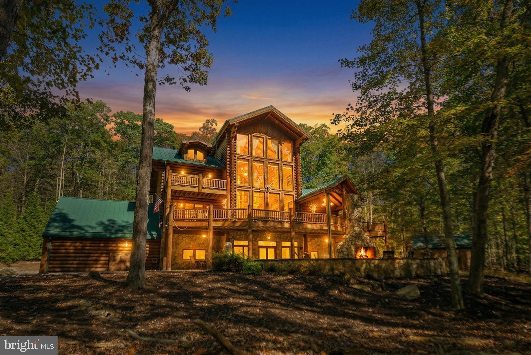 Welcome to 2725 Stockslager Road, one of Deep Creek Lake's most coveted properties. This custom-built log home is set against a picturesque landscape in Western Maryland, offering breathtaking nature views and embodying mountain charm and adventure. This home showcases impeccable craftsmanship, seamlessly blending with its natural surroundings while providing unrivaled comfort. Nestled on 1.03 acres, it ensures abundant privacy and is just a short, level walk to lake access with a deeded dock slip. 

With soaring cathedral ceilings that bathe the interior in natural light, the home features four finished levels, providing generous space for everyone. The property itself boasts a luxurious soaking hot tub, sauna, multiple bars, a family room, game room, den, dual washers and dryers, bar areas, an exquisite outdoor fireplace, a new Blackstone grill, radiant floor heating, and a custom wine barrel deck firepit along with an attached two-car garage and a detached 2-car garage with unfinished loft space.

Recently upgraded with several enhancements, this meticulously maintained home features fresh exterior staining,  a Savant home control system, a house generator, a new alarm system, and two new hot water heaters and boiler for radiant floor heating. New outdoor furniture and LED lighting enhance the exterior ambiance.

Inside, you'll find a warm and elegant atmosphere, featuring a native stone gas fireplace and custom touches that add rustic charm. Retreat to one of five en-suite bedrooms, each designed for maximum comfort with a private bath and a cozy fireplace. The loft area offers stunning views, perfect for entertaining or quiet relaxation.

Don’t miss this rare opportunity to own a remarkable property that seamlessly combines luxury, comfort, and natural beauty in the prestigious Sandy Beach community of Deep Creek Lake. This residence epitomizes resort living.  Schedule your private tour today to discover the pinnacle of Deep Creek Lake real estate. Adjoining lot is also included in the sale giving you an additional 1.03 acres of privacy.