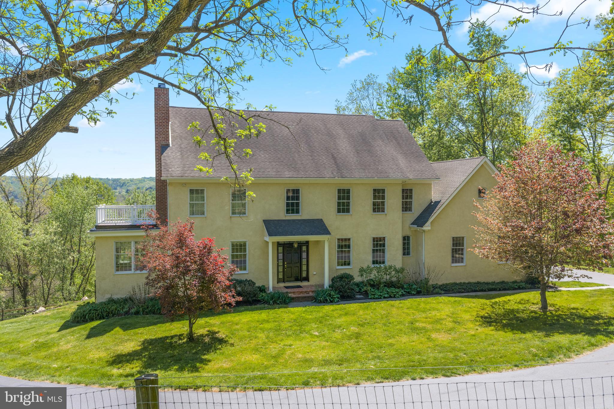 Set atop a scenic hilltop in picturesque Newlin Township within the highly sought-after Unionville-Chadds Ford School District, this exceptional custom-built estate offers over 10 breathtaking acres with sweeping pastoral views overlooking the Brandywine Creek. A rare blend of timeless elegance, privacy, and country sophistication, this remarkable property is designed for both luxurious living and equestrian enjoyment. A gracious center hall entrance welcomes you with stunning wide-plank pine floors and refined architectural details throughout. The formal dining room provides an elegant setting for entertaining and holiday gatherings, while the inviting living room features a marble-surround wood-burning fireplace. French doors open to a sun-drenched private study, where expansive countryside views create the perfect work-from-home retreat. Designed for everyday comfort and entertaining alike, the spacious country kitchen with a breakfast room flows seamlessly into the warm and inviting family room, complete with a second fireplace and French doors leading to a charming brick balcony overlooking the rolling landscape. The main level also includes a well-appointed laundry room, powder room, and access to the oversized three-car garage. Upstairs, the luxurious primary suite serves as a peaceful sanctuary, featuring a private balcony ideal for morning coffee and sunrise views. The spa-inspired bath offers dual vanities, an oversized shower, and generous walk-in closets. Three additional spacious bedrooms provide abundant closet space, complemented by a hall bath with double vanities. A versatile bonus room at the end of the hall is currently utilized as a home office but could easily function as a fifth bedroom, studio, or fitness space. The walk-out lower level presents endless possibilities for customization, already featuring a wood-burning fireplace and rough-in plumbing for a future full bath. Perfectly suited for equestrian enthusiasts and outdoor living, the property includes a beautifully designed four-stall center-aisle barn with tack room and wash stall, two expansive paddocks, and a turnout shed. A charming chicken coop and pen add to the property’s idyllic farmstead appeal. A long private drive leads to an additional 36’ x 32’ outbuilding, ideal for equipment storage, workshop space, or collector vehicles. For additional outdoor enjoyment, property is a short hack to Cheslen Preserve. Comprised of three tax parcels and enrolled in Act 319, this extraordinary property offers both prestige and practicality, all within convenient proximity to West Chester, Kennett Square, Delaware, fine dining, and boutique shopping.