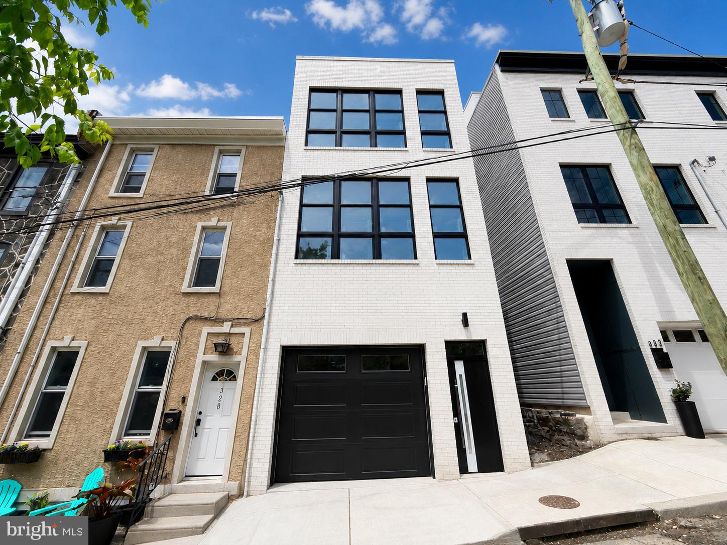 Welcome to 330 Carson Street, a beautiful new construction home in the heart of Manayunk, just minutes from Main Street, local restaurants, coffee shops, parks, trails, and easy access into Center City Philadelphia. This thoughtfully designed 3-story residence features tasteful finishes throughout, extra-high ceilings, durable LVP flooring, and a convenient front-loaded garage. The main level offers a bright and spacious open-concept living, kitchen, and dining area, creating the perfect layout for everyday living and entertaining. Oversized windows at the front, rear, and along the side of the home fill the space with natural light, giving the home an open and airy feel. A powder room and access to the rear patio complete the first floor. The second level includes two well-sized bedrooms, a full bathroom, and a dedicated laundry room. The third floor is home to the private primary suite, featuring a large walk-in closet and a spa-like bathroom with a soaking tub, elegant finishes, and a relaxing retreat-like feel. There is also the option for a wet bar leading up to the expansive roof deck. Enjoy outdoor living from both the rear patio and the incredible rooftop deck, offering sweeping views of Manayunk and the Philadelphia skyline. Located near the best of Roxborough and Manayunk, with quick access to Main Street, Wissahickon Valley Park, Kelly Drive, public transportation, shopping, dining, and major commuter routes, this home combines modern new construction living with one of Northwest Philadelphia’s most convenient locations.