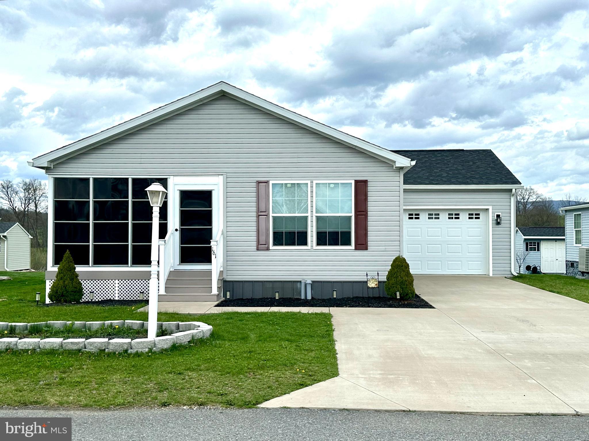 This beautifully maintained 2020 doublewide home offers modern comfort and thoughtful upgrades throughout. A bright and inviting sunroom overlooks the screened-in porch, complete with sliding glass doors--perfect for relaxing or entertaining. Inside, you'll find elegant finishes including crown molding and custom electronic cloth window blinds with remote operation. The spacious layout features an extra-wide hallway and a large living room accented by built-in cabinetry. The galley-style kitchen is both stylish and functional, showcasing mocha finished cabinetry, quartz countertops, recessed overhead lighting, a pantry, and an eat-in bar that flows into the dining area. New appliances complete the space. Bedrooms are generously sized with ample closet space, while the versatile den (or optional bedroom) includes sliding door access to the backyard. The primary suite offers a private retreat with two large closets, dual vanities with an expansive mirror, and a walk-in shower. Additional highlights include a conveniently located laundry area just off the kitchen, easy access to a 14x24 one-car garage, and a separate shed for extra storage. This home blends comfort, style, and practicality--ready for you to move right in! Arrowhead Acres is a 55+ Community. New Owner will apply at the Main for application and requires a background check.