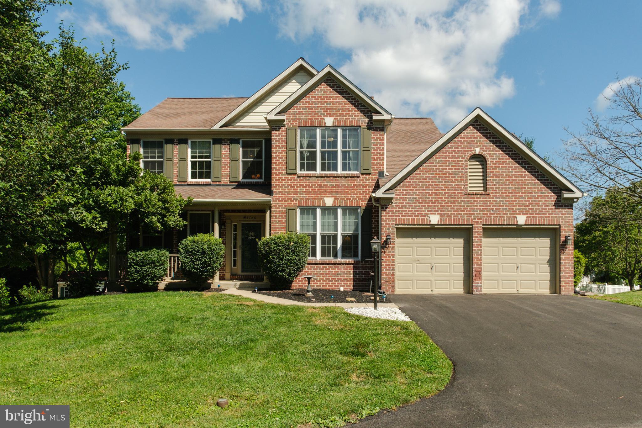 Welcome to this brick front colonial with a welcoming front porch and a well-designed floor plan offering both formal and casual living spaces. Hardwood flooring, trim accents, and fresh paint extend throughout much of the main level. This house offers a formal living room and a formal dining room highlighted by a bay window. The updated eat-in kitchen features granite countertops, copper farmhouse sink, stainless steel appliances, gas cooking, an island with pendant lighting, recessed lighting, and direct access to the deck through a sliding glass door. The adjoined family room offers updated carpeting and a wood-burning fireplace. A designated office with an accent wall currently serves as a mudroom & can easily be converted back to an office. The main level laundry room features beautiful tile flooring, an updated stackable washer/dryer and garage access. Upstairs, updated carpeting continues throughout. The primary suite includes a walk-in closet and luxurious primary bath with a double-sink vanity and an oversized walk-in shower finished with gorgeous tile. Three additional bedrooms and a full hall bath complete the upper level. The finished lower level has been updated with new LVP flooring and a remodeled full bath. A walkout provides direct access to the fenced rear yard. Outside includes a two-car garage & mature landscaping. Conveniently located near great commuter routes, shopping, dining, medical facilities, parks, and Historic Downtown Sykesville.