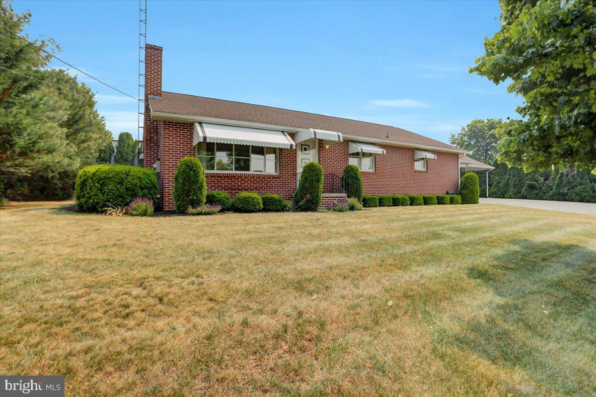 This beautiful all-brick home is ready for it's second family! This one-homeowner rancher is absolutely immaculate and has been beautifully maintained over the years. The main living room features a bright bay window and a cozy wood burning fireplace. You are bound to notice the gleaming hardwood floors here and, the best part is, they are carried throughout the majority of the home, including all three bedrooms. The middle room could be used as a formal dining room or as another hang out area. The large kitchen has a ton of cabinet space and plenty of room to house a dining table for easy breakfasts and family meals. The bedrooms have generously sized closets. Although there is only one bath on the main level, the double sink vanity provides plenty of space to share. Downstairs, the finished basement features a huge family room that is cool in the summer and heated in the winter. Another full bath, a bright and clean laundry room and a storage area complete the basement level. There is also storage area available in the attic. Outside, the oversized 41 x 37 ft six car garage is sure to be someone's favorite feature of this property. There are three garage doors that provide access to the inside. Additionally, there is a solid block shed out behind the house that has it's own wood stove. This would be the perfect place to tinker or create throughout the cold winter months. A second lot measuring .52 acres provides plenty of space to play, practice sports, or garden. The house has a generator back-up and the generator conveys with the purchase of the home.  Country views can be enjoyed to the front and back of the home. Within walking distance to Hopewell Township park, your family can enjoy walks or bike rides along the trail. The playground and splash pad are also a favorite. This home has so much to offer. Check it out by scheduling a tour!