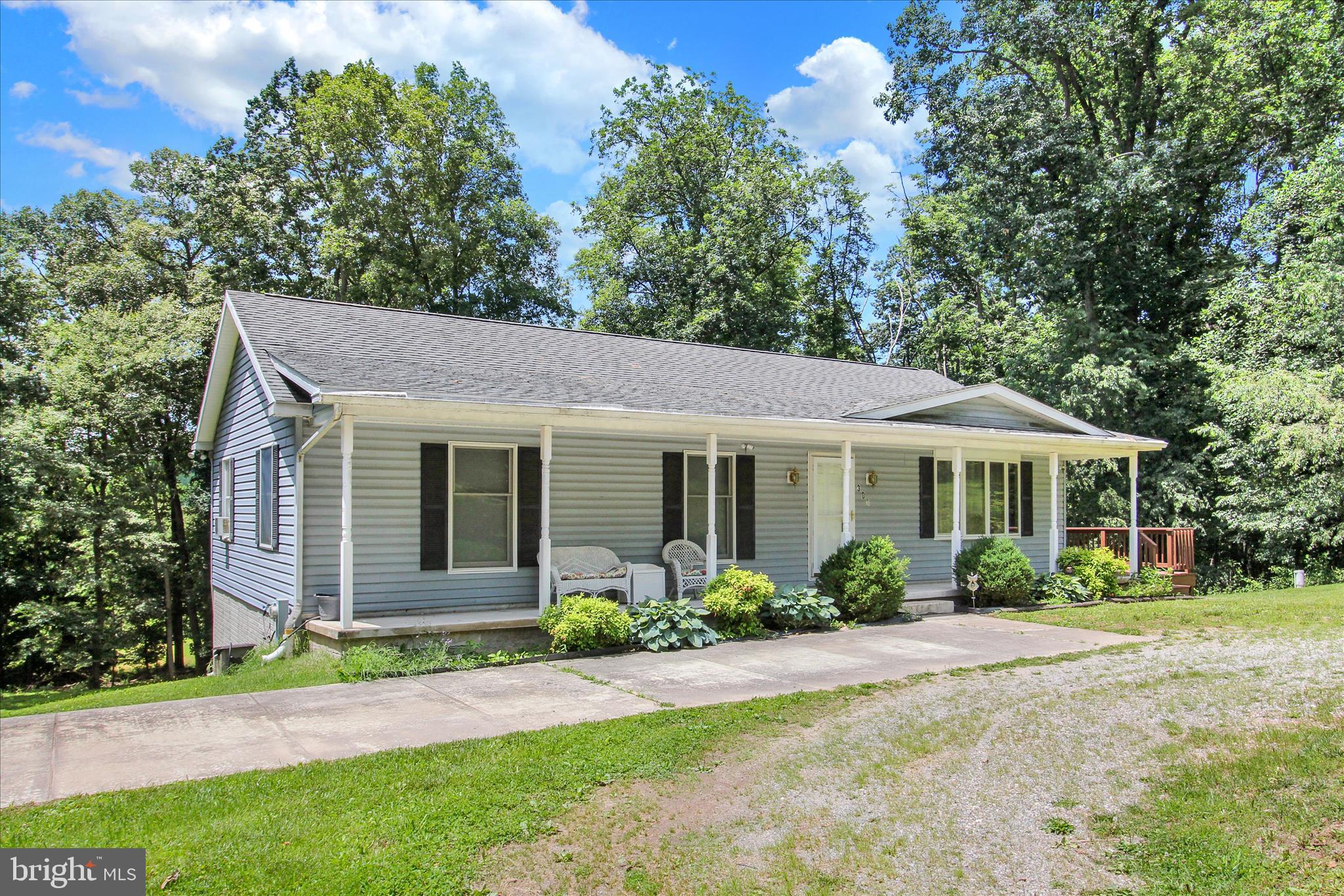 Enjoy one level living in a peaceful setting and convenient location with this 3 Bedroom 2 Full Bath Rancher on a full acre surrounded by trees.  Main level greets you with a spacious living room and generous kitchen space with dining area.  Ample primary bedroom hosts a Full Bath with Walk-In Shower.  Bedrooms 2 and 3 are nicely sized with oversized windows in the front allowing for lots of natural light.  Unfinished basement features a laundry area, and tons of potential with open space and a sliding door that opens out to the back yard.  Outside you'll find a lovely covered front porch that wraps around to a huge deck overlooking the backyard providing tons of outdoor living space. Sold AS IS.