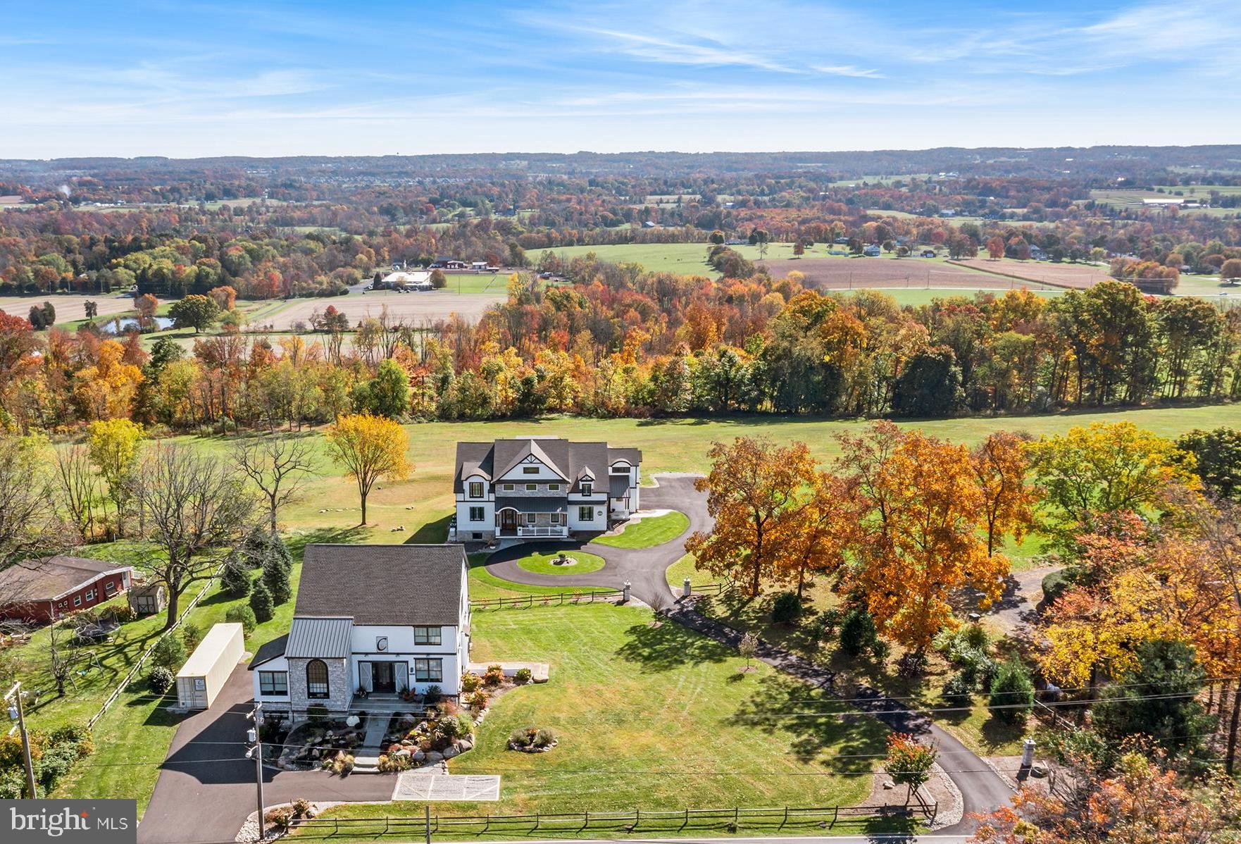 Set on 12.48 breathtaking acres in scenic Perkasie, this exceptional custom estate offers a rare blend of luxury, privacy, and lifestyle—just minutes from Lake Nockamixon.  This one of a kind estate features a custom Casadonti Home built in 2024 as well as an incredible separate office/studio/family entertainment center.  A grand approach welcomes you through stately stone pillars with lighting, leading to a sweeping circular driveway and a home that impresses from the very first glance.
Inside, this beautifully crafted residence features 5 bedrooms and 5.5 bathrooms, with incredible long-distance views showcased from nearly every window. The heart of the home is the expansive gourmet kitchen, complete with Café appliances, soaring 12-foot ceilings, and an open layout flowing seamlessly into the family room—perfect for both everyday living and entertaining. The kitchen has a huge pantry as well as a scullery pantry.     A sunlit dining room with walls of windows captures the surrounding landscape, creating an unforgettable backdrop for gatherings.  Dining room is open to the large outdoor deck and patio.
The first floor includes a private guest suite with its own office/living area, offering comfort and flexibility for extended family or visitors. Separate family entrance into the huge mudroom area with access to the private guest suite.  Upstairs, you’ll find four generously sized bedrooms, including an en suite, a hall bath, and a luxurious Owner’s Suite featuring a spa-like bathroom with soaking tub, walk-in shower, and dual vanities. A spacious second-floor laundry room with cabinetry and sink adds everyday convenience.
The finished third floor is a versatile retreat with stunning views—ideal for a second office, yoga or fitness space, playroom, hobby studio, or quiet escape. The fully finished walk-out lower level expands your living space even further, offering a large great room, exercise room, additional finished rooms for flexibility, and a full bath.
Every detail of this home reflects quality craftsmanship, from the oversized 3-car garage to the rich character of solid knotty alder wood doors throughout. A deck and patio off the dining room provides the perfect setting to relax and take in the peaceful surroundings.
What truly sets this extraordinary property apart is the separate, fully rebuilt and thoughtfully designed barn—transformed in 2024 into a one-of-a-kind family entertainment center, office or lifestyle space- perfect for hosting, recreation and making lasting memories. This stunning structure offers an expansive open gathering area, complete with a kitchenette and full bathroom, making it ideal for entertaining, hosting guests, or creating the ultimate family fun center.  Outside, a tranquil water feature, complemented by a flagstone walkway and steps, enhances the serene, resort-like setting.
Opportunities like this are rare—a nearly new private luxury estate offering both a magnificent main residence and a separate, equally impressive structure that elevates the property to a level unlike any other.  Award winning Pennridge School District.   Great investment and low property taxes through Act 319.