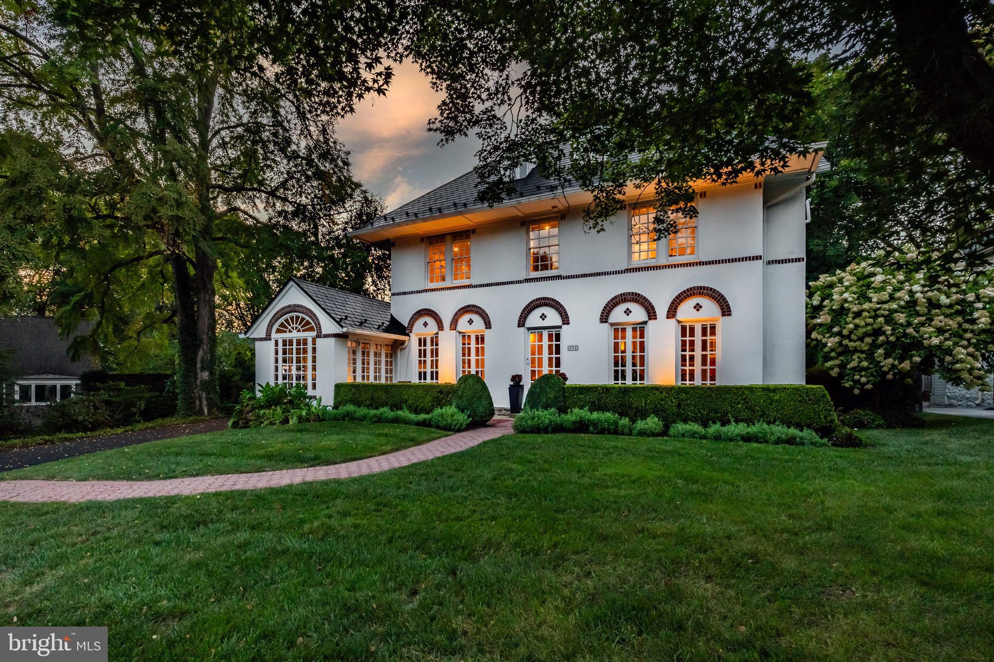 In a class of its own.  Welcome to 205 Roberts Rd, one of the most beautiful homes in Ardmore, with its unique Mediterranean Revival style, offering a location within a short walk to Suburban Square and so much more.  This stunning home features 5 bedrooms, 3.5 bathrooms and more charm than you’ll know what to do with!  Pull up and immediately fall in love with the beautiful design details of this early 1900's home, rich with architectural characteristics everywhere you turn.  The first floor has a wonderful flow to include a large and sunlit living room with 3 sets of French doors leading to the front porch, a classic fireplace, coffered ceiling and the original oak hardwoods in a beautiful honey tone.  Off the living room is the sunroom, a great space for lounging or entertaining guests with it's heated floor and beautiful windows.  The formal dining room has room for a larger table and server, also with French doors leading out front.  The eat-in kitchen has a butlers pantry area with original cabinetry and makes a great party set up or coffee bar, maple cabinets, granite counters, stainless steel appliances including top of the line fridge,  Wolf steamer, 2 tiered island with storage and a great breakfast nook with access to the back bluestone patio and private fully fenced backyard.  The half bath is perfectly tucked away under the stairs.  Use the front or back stairs to head on up! The primary suite is spectacular!  The bathroom was recently renovated to include Antracita Porcelain tile from Spain, a Bocchi Contempo fireclay farmhouse sink which is designed in Italy, a bidet, heated flooring and the most chic shower in town!   It’s truly one of a kind.  The primary bedroom has plenty of closet space tucked away behind custom slider doors that tie beautifully to the bathroom.  There are 2 more spacious and sunlit bedrooms on the second floor and another full bath.  Up on the 3rd floor are 2 more bedrooms and a 3rd full bath with a claw foot tub and a great view of the picturesque property.  The versatility of the floor plan is perfect for work at home, hosting guests or just the need for 5 bedrooms!  The walk-out basement is clean as a whistle and thoughtfully updated to include new flooring, new sink and cabinet, the installation of a full glass door to let the light in, tons of storage cabinets added and parging of the walls make this a great space for working out, doing laundry or just nice clean storage.  The property itself is perfectly private in the back, has a phenomenal 2 car detached garage with the original barn doors and a 2nd floor loft that can be converted into something magical.  Entertain your guests on the patio, surrounded by lush landscape and a natural privacy screen.   The current owners have poured love and resources into this home.  A perma lock metal roof with a lifetime warranty, updated electrical and many other thoughtful upgrades make this a phenomenal value.  This home gleams with old world detail, custom mouldings and is located in one of the best locations Ardmore, Lower Merion has to offer.   Walk to Suburban Square in minutes and enjoy upscale shops, cafes, a farmers' market with easy access to the train.  Enjoy live music at Ardmore Music Hall, a craft beer at Tired Hands or a movie at Bryn Mawr Film Institute.  This home offers a lifestyle and location that you’ll never want to miss.