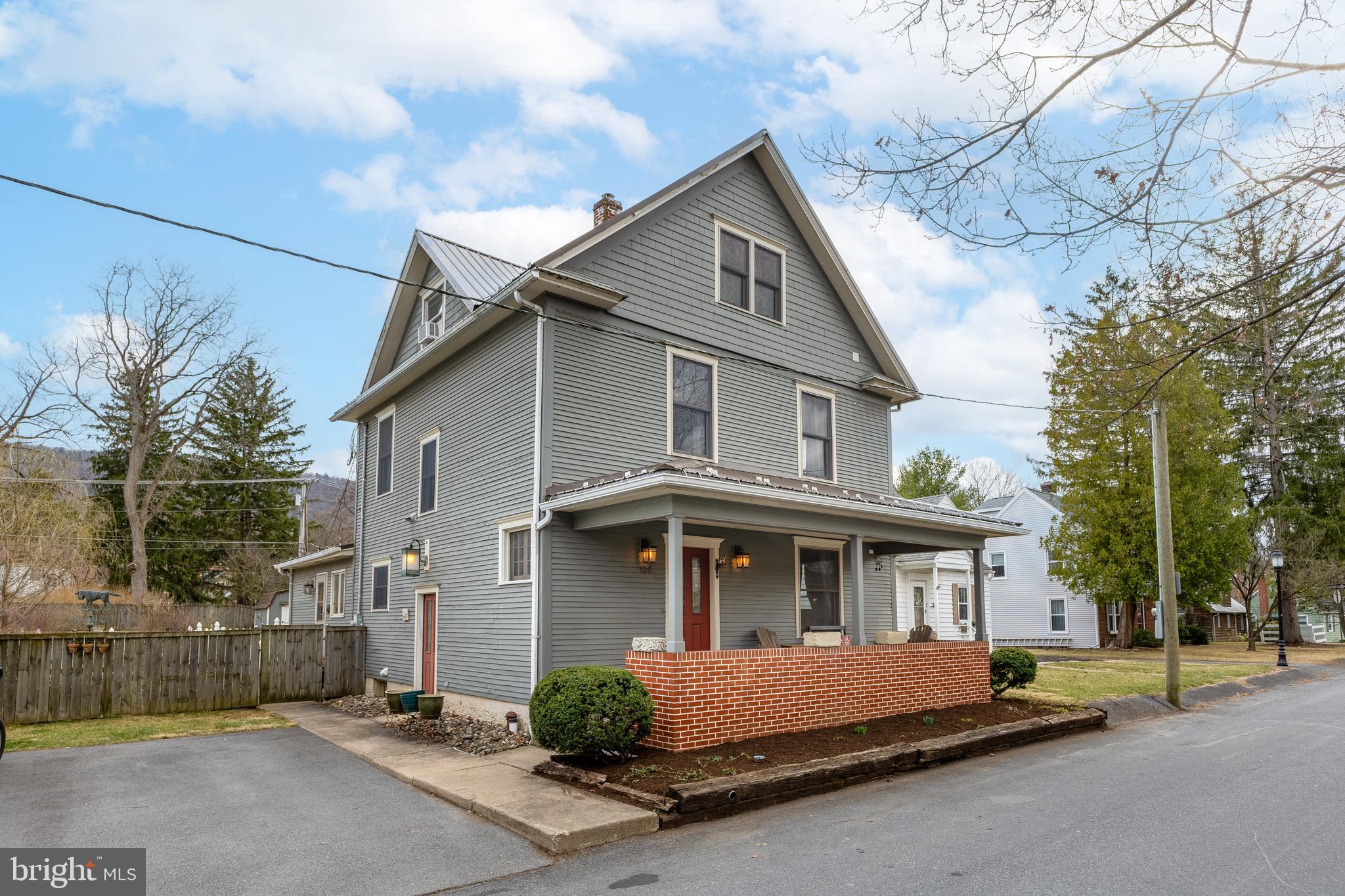 Rich in charm and character this residence in desirable Historic Boalsburg will embrace you. The kitchen boasts beautiful fire slate countertops, stainless steel appliances, and plenty of counter space for all your culinary needs. Rich hardwood floors flow seamlessly through the dining and living areas, where expansive windows create a bright, airy ambiance. The family room is highlighted by a cozy wood-burning fireplace and opens to a sweet porch, complete with a fenced-in outdoor space for added privacy. New residents will also appreciate the garden area, which includes a well-established asparagus patch.  Upstairs, you'll discover three generous bedrooms with hardwood floors and a full bathroom. The third floor features a versatile room with a spacious walk-in closet, soaring vaulted ceilings, and exposed brick walls, infusing the space with distinctive charm. The lower level is fully equipped with a laundry area and offers ample storage space. Enjoy the convenience of being just a short walk to quaint shops, tasty restaurants, coffee shop and more. Additional parking is available in the alley.