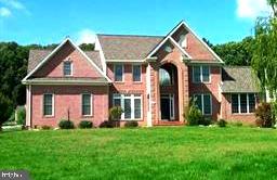 Welcome to this stunning brick-front Abbey model by Trinity Homes, featuring a desirable 2-foot front extension and located in the highly sought-after Woodfords Grant community. Offering an impressive 6,186 square feet of finished living space, including 4,184 square feet above grade, this exceptional Colonial combines elegance, functionality, and comfort throughout. Step inside to discover a grand two-story foyer accented by dual staircases and beautiful hardwood flooring. The refreshed gourmet kitchen is a chef's dream, showcasing quartz countertops, center island, custom tile backsplash, cooktop, and abundant cabinetry. The kitchen opens seamlessly to the dramatic two-story family room, highlighted by a cozy propane gas fireplace and walls of windows that fill the space with natural light. Designed for both entertaining and everyday living, the main level also features formal living and dining rooms, a private first-floor office, spacious laundry room with cabinetry, and a sun-filled morning room with sliding glass doors leading to the deck. The luxurious primary suite serves as a private retreat, complete with tray ceilings, dual walk-in closets, and an expansive spa-inspired bath featuring a Jacuzzi soaking tub, separate shower, dual vanities, tile flooring, and linen closet. Three additional generously sized upper-level bedrooms provide ample space, including two bedrooms with their own private full bathrooms. The fully finished lower level expands your living space even further and includes a dedicated theater room, recreation room, fifth bedroom/flex room, and full bathroom—perfect for guests, extended family, or entertaining.
Recent updates include fresh paint and new carpeting, making this home truly move-in ready. Ideally located within a top-rated school district and just minutes from shopping, dining, and major commuter routes, this exceptional Woodfords Grant residence offers the perfect blend of luxury, convenience, and timeless appeal.
