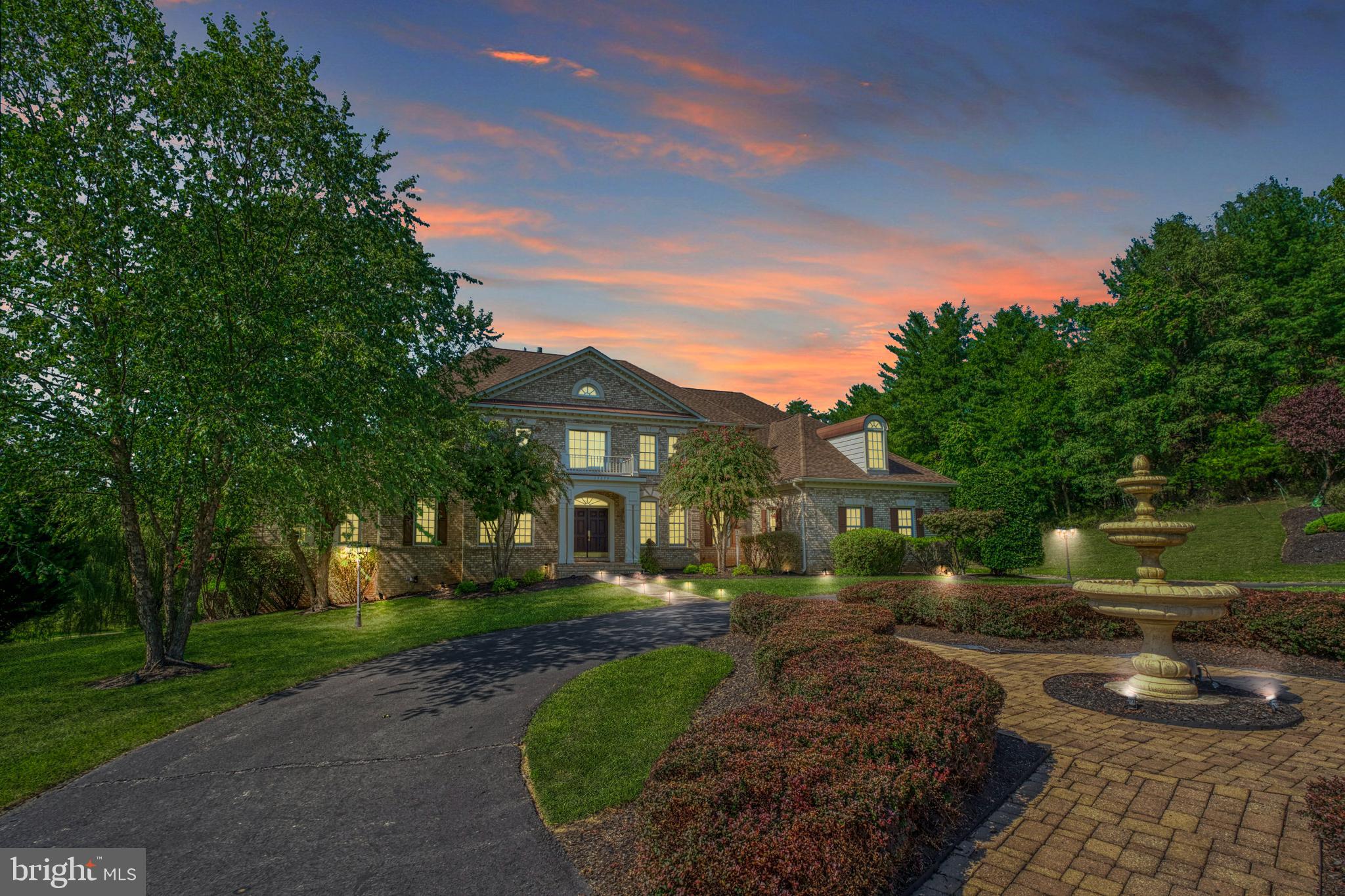 Overlooking 3.89 private acres in distinguished Beacon Hill, this beautifully constructed 9,214 square foot residence offers a seamless blend of indoor and outdoor living, ideal for both sanctuary seekers and entertainers alike. From within the brick-wrapped facade, overlooking a stately circular drive, a rarely seen two-story solarium invites natural light and a place for horticulturalists and sun-seekers to linger, while the home’s living and entertainment spaces welcome with soaring ceilings, elegant custom moldings, and striking showcase chandelier. Complete favorite recipes in the gourmet kitchen or let your favorite caterer complete bites within the expansive lower level’s secondary full-kitchen. Here, complete routines in the gym, mix drinks at the handsome wood-clad bar, host screenings in the theater, or head outside where lush grounds dotted with spring-blooming fruit trees shade a resort-worthy pool, expansive deck, stone-lined hardscapes, and strolls to nearby walking trails. Six sunlit bedrooms and six-and-a-half baths include a main-level suite - ideal for quiet escapes and multigenerational living. While on tour, visit the elegant dining room and note endless custom built-ins providing ample space and architectural interest. From home, historic downtown Leesburg, Wine and Hunt Country, commuter routes, and entertainment destinations await, just moments away.