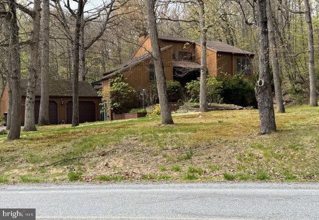 Don't wait to see this 3 or 4 Bedroom Contemporary in a wooded setting. The 4th bedroom is presently being used as a living room for guest quarters that also has a bedroom, bathroom, and a kitchenette. That living room can easily be used as the 4th bedroom with a bathroom between bedroom 3 & 4 and a kitchenette for evening snacks. The living room has a fireplace and a sliding glass door that leads to a large wrap around deck. Sit on the deck to enjoy the wooded setting that looks at the hot tub and pool. The pool, filter, heater, and hot tub have not been used for up to 10 years and are in "as is" condition and will require maintenance. The eating area has room for a table PLUS there is a breakfast bar to have a quick meal. The kitchen includes a dishwaher, range, and Jennaire. The second level has 2 more bedrooms.  Between the bedrooms there is a laundry room/ bathroom combination. The basement could be finished for additional living space if you desire more room. This home has everything you need and is waiting for you to do any updates you desire to  the pool and the deck and make it your own. Don't delay, see it today!