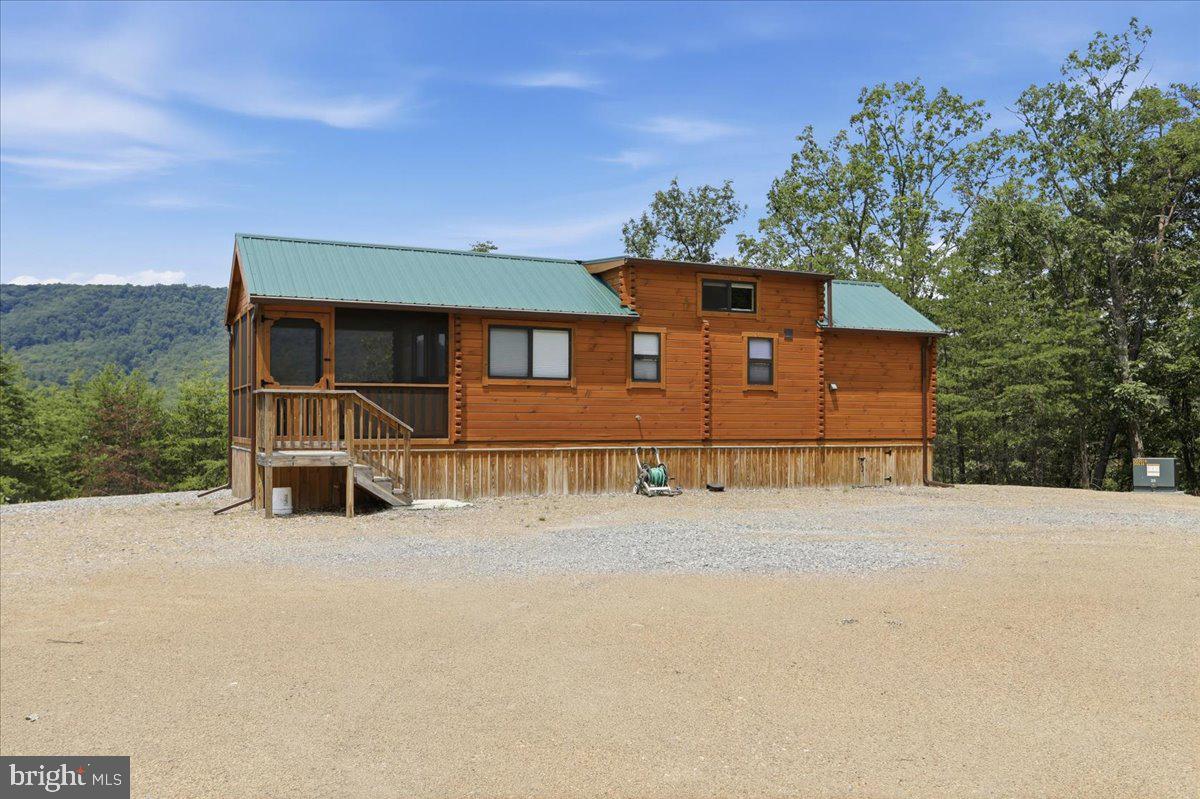 Privacy, Privacy, Privacy! If you're searching for the perfect West Virginia getaway, look no further! Nestled on 24.3 beautifully wooded acres, this incredible property offers exceptional privacy, stunning mountain views, and the peaceful seclusion you've been dreaming of.  The property features a 2023 Log Cabin Park Model Home that is fully furnished and move-in ready. Comfortably sleeping 6+ guests, it includes a full kitchen, full bathroom, private bedroom, loft sleeping area, washer and dryer, water filtration system,  mini-split heating and air conditioning for year-round comfort.  Start your mornings with a cup of coffee or unwind in the evenings on the spacious screened-in porch, where you can relax while surrounded by the sights and sounds of nature.  Outdoor enthusiasts will love the property's dense hardwood forest, gently rolling and easily walkable terrain, and the small stream that meanders through the front portion of the property. Unlike many mountain tracts, there are no steep drop-offs or rocky terrain, making this land ideal for hiking, exploring, hunting, or simply enjoying the outdoors.
Hosting friends and family is easy thanks to the separate full RV hookup site, complete with 30-amp electric service, water, and septic.  Additional features include - Private gated entrance - Beautiful mountain views – No HOA dues - High Speed Fiber Optic internet service - Excellent road frontage with convenient access directly from the main road - Just minutes to Romney for dining, shopping, fuel, and everyday conveniences .  Whether you're looking for a private family retreat, hunting camp, weekend escape, or investment property, this property provides the perfect combination of privacy, convenience, and turnkey enjoyment. You'll feel like you're miles away from the hustle and bustle while still being only minutes from town.  Public access to the South Branch of the Potomac River is nearby for fishing, floating, kayaking!