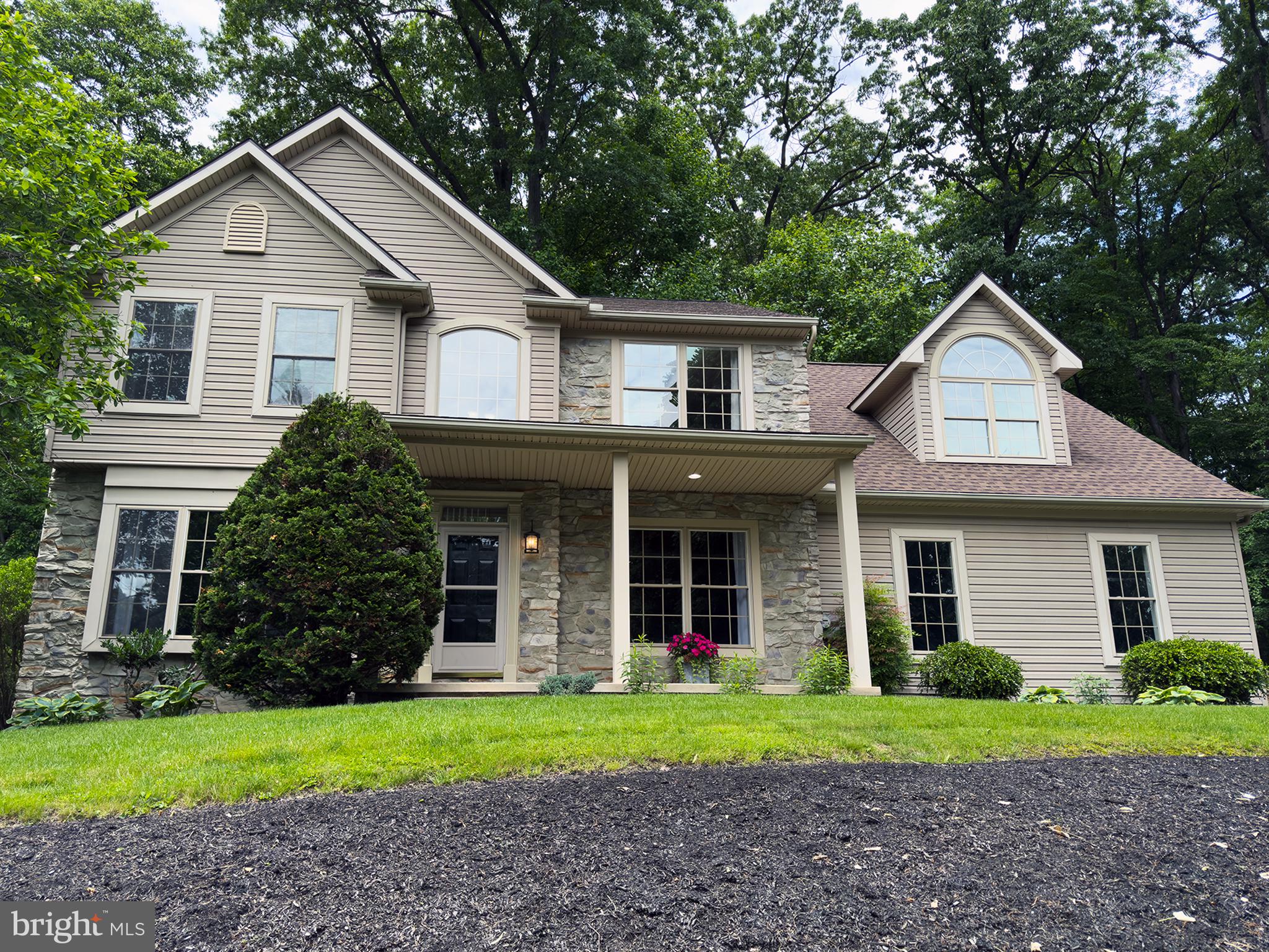 Stunning 2-story colonial located in the Hempfield School District offers a private wooded setting, mature trees and landscaped, fenced, back yard. It also boasts a paver patio with multiple outdoor gathering areas excellent for entertaining and accessed through Andersen custom sliding patio doors.  Professionally landscaped grounds with retaining walls and tiered plantings. The attractive cast stone facade accents the large windows and covered front porch. The heated and air conditioned 3 car garage with EV charging capability compliments the wide driveway and generous parking area.  Over 3,100 square feet in West Hempfield Township that's move-in ready. Bright, and thoughtfully designed for both everyday living and entertaining. Located just a short walk from Lake Grubb Nature Park with convenient access to Route 30 and Route 283, this home combines a peaceful setting with easy connectivity. Inside, natural light is a defining feature. Transom windows in the gathering room and kitchen bring in soft, consistent light while framing mature wooded views behind the home; creating an open floor plan without sacrificing privacy. Hardwood floors run throughout, and 9-foot ceilings on the main level add to the home’s sense of openness and flow. The main level powder room is convenient for guests. The remodeled kitchen is designed to connect both visually and functionally, with the surrounding living spaces. Making everything from daily routines to hosting guests feel effortless. The cabinetry is rich in appearance. The granite countertops provide lasting quality with extended eat-in seating.  There is a tile backsplash with under cabinet lighting.  Recessed lighting throughout the kitchen. A quartz Double basin sink, stainless steel double oven range, dishwasher, refrigerator, and vent hood make for a beautiful and functional area to prepare meals.  The open layout of the breakfast nook provides easy access to the gathering room.  Large rear windows with transom give views of gardens, koi pond with stacked stone waterfall, and woods. In the gathering room, built-in surround sound and whole-house speaker wiring (with blueprints provided) enhance the experience whether you're entertaining or enjoying a quiet evening at home. Upstairs, the second floor offers a spacious layout with four bedrooms and the convenience of a second-floor laundry with sink and oversized front load washer and dryer plus an auxiliary pedestal washing machine for a small or specialty load. The owner’s suite is a true retreat, featuring a vaulted ceiling. A beautifully remodeled bathroom with tile flooring, spa inspired design, dual vanities with granite countertops, recessed lighting, free standing tub and walk in, "rain fall" shower.  There is also a private toilet room. The suite also includes five large windows, French door entry, space for sitting, hardwood flooring, and two walk-in closets. One of the most memorable spaces is the oversized fourth bedroom, where a vaulted nook with an arched window fills the room with natural light and creates a cozy, inviting spot perfect for a reading corner, office, media room, or quiet retreat. The room also includes a dedicated hobby area and a walk-in closet. The room offers flexibility to suit your needs. The "2nd" bedroom includes hardwood flooring, a large storage closet, and a sunny south facing window. The "3rd" bedroom also features hardwood flooring, large storage closet and another south facing window. The main hall bath has an extended single sink vanity, tub and shower, abundant counter space and storage, with a view of the wooded back yard.  The home offers built in shelving, and surround sound speakers.   There is a full unfinished basement with 9-foot poured concrete walls, offering exceptional potential for future finished living space. With its combination of space, light, thoughtful upgrades, and a private outdoor setting, this home offers a lifestyle that’s both comfortable and hard to replicate.