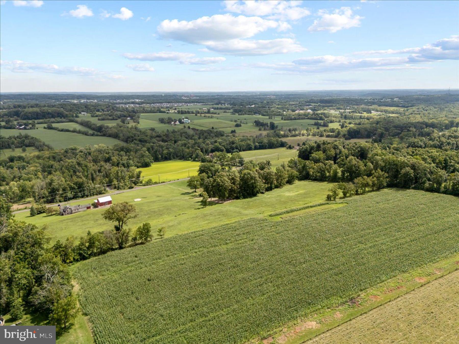 Rare opportunity to own over 27.6 +/- acres across three separate parcels on one of Plumstead Township’s most scenic country roads. Surrounded by rolling farmland, preserved open space, and long-distance views, this unique offering presents exceptional possibilities for a private estate, equestrian property, agricultural use, multigenerational living, or investment.
Lot 1 (10.51 acres) features an existing stone farmhouse and barn (circa 1845 +/-). []  An approved 4-bedroom septic permit, including an in-law suite component, will transfer to the buyer. Installation of the septic system is required. Historic structures must remain and offer significant restoration potential.
Lot 2 (11.63 acres) is an approved building lot with permits in place for a 5-bedroom residence and driveway.  An approved septic permit is in place for a 5 bedroom house.  A beautiful homesite surrounded by preserved land and scenic countryside.
 Lot 3 (4023 Curly Hill Rd – 5.6 acres) includes a Cape Cod-style home in need of complete restoration and multiple outbuildings. No restrictions apply to these structures, allowing them to be renovated, repurposed, or removed. Subdivision potential exists.
 Lot 1 and 2 are enrolled in Pennsylvania’s Clean and Green Program (Act 319), providing favorable tax benefits while preserving the area’s natural beauty. Approved septic permits for traditional sand mound systems are in place for Lots 1 and 2, allowing a buyer to move forward with development plans.  All Lots are conveyed under separate deeds.
Ideally located just minutes from Doylestown Borough’s shops, restaurants, museums, and cultural attractions, this offering combines the tranquility of country living with convenient access to everyday amenities. A truly exceptional opportunity to create a legacy property in the heart of Bucks County.