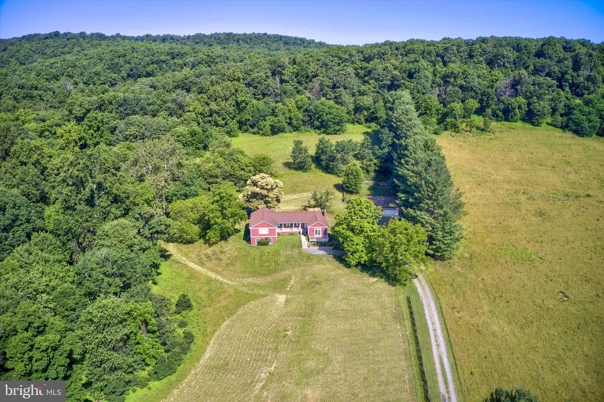 Mountain views, open pastures, and 10 beautiful acres create the perfect Western Loudoun retreat. Located just minutes from historic Hillsboro and downtown Purcellville, this updated property offers nearly 4,000 finished square feet, privacy, and endless possibilities.

Originally built in 1969, the home has been extensively updated over the years. Major improvements include HOt Water heater (2025) Washer & Dryer (2024), Windows and Doors (2013), complete Electrical Rewiring (2013), a 20'x50' addition (2014), a remodeled kitchen with cabinets and appliances (2014), new septic system (2014), Roofs on the house and garage (2014), Siding on the garage and sunroom (2014), Replacement HVAC system (2020), Barn Roof (2021), and a finished 20'x50' lower level completed in 2022. Additional improvements include upgraded insulation, backup generator system, and attic insulation upgrades.

The main level features hardwood floors, high ceilings, abundant natural light, and beautiful views from nearly every room. The updated kitchen opens to the living and dining areas, while the family room offers a wood-burning fireplace. The spacious sunroom with vaulted ceilings is the perfect place to enjoy the surrounding countryside year-round.

The primary suite offers peaceful views and a private bath. A secondary bedroom includes a private bath, while the third bedroom is served by a full hall bath. An oversized laundry room provides additional storage and everyday convenience.

The walkout lower level includes a fourth bedroom, full bath, and large recreation room. Approximately 1,000 square feet of unfinished space offers storage or future expansion opportunities.

Outdoor living includes a front porch, rear patio with pergola, mature landscaping, and scenic mountain views. The property is currently enrolled in open space use and offers numerous opportunities. 

The three-stall barn conveys as-is. The detached 1,540-square-foot garage and workshop includes a heated section and provides exceptional space for vehicles, hobbies, equipment, or a home business.

Currently operates as a successful AIRBNB| VRBO (short-term rental), this unique property offers opportunities as a private residence, weekend retreat, equestrian property, or investment opportunity. Conveniently located just off Route 9 with easy access to Airport, Purcellville, Hillsboro, wineries, breweries, and commuter routes.