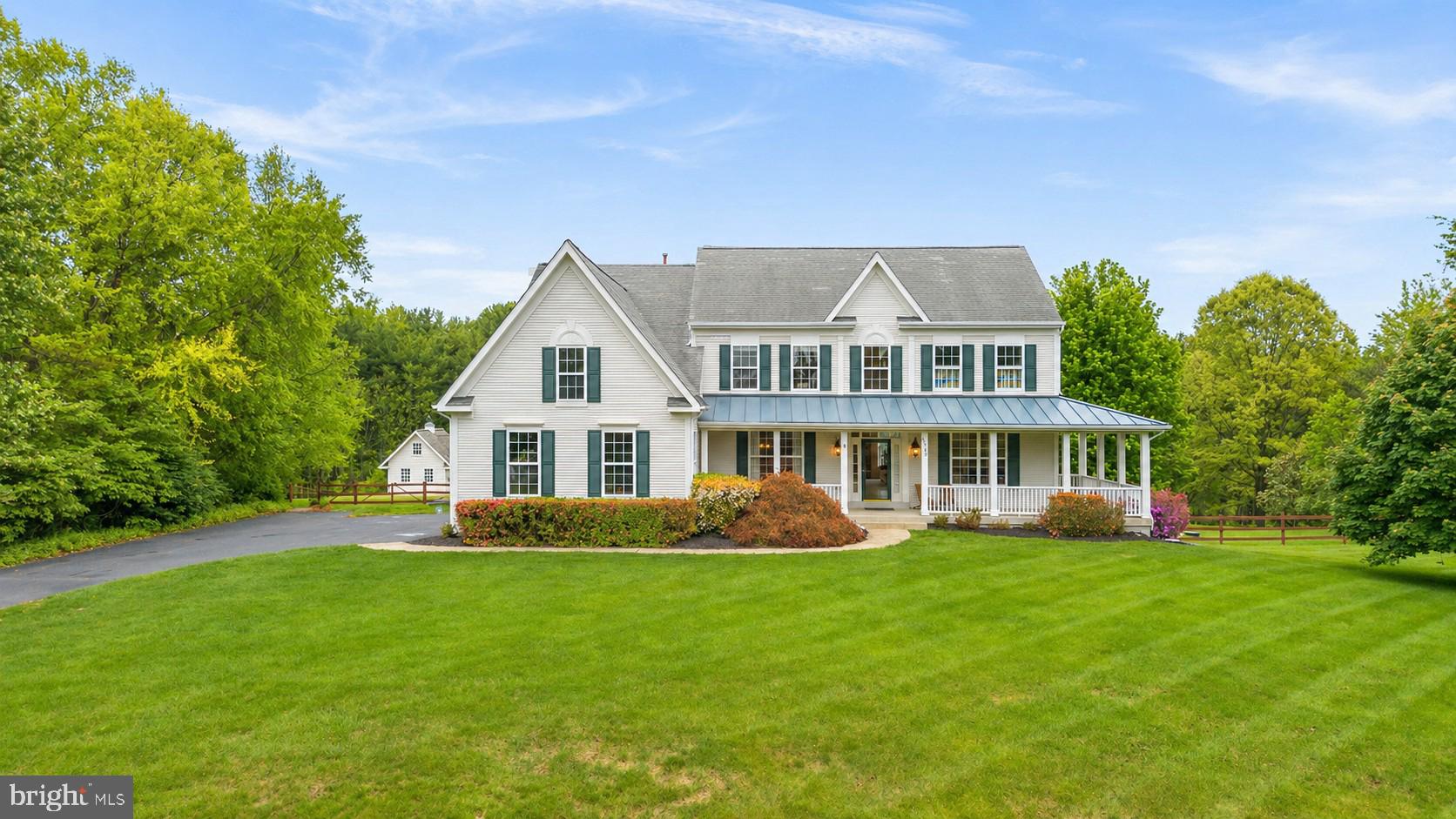 Original owners and beautifully maintained, this home has been thoughtfully cared for and updated over the years. From the moment you arrive, the oversized wraparound front porch sets the tone, welcoming, relaxed, and ready to impress.

Set on 3.64 acres, including over an acre of wooded land and backing to Agricultural Preserve farmland, this property offers a rare sense of space, privacy, and scenic beauty.

Step inside to a stunning two-story foyer with hardwood floors, flanked by formal living and dining rooms. The main level opens up to an easy, inviting layout where the family room, kitchen, and sun-filled, window-lined breakfast room all connect seamlessly, perfect for everyday living and entertaining.

The gourmet kitchen features granite countertops, stainless steel appliances, a gas oven, and both under and over-cabinet lighting. A center island with a breakfast bar keeps everyone connected. The family room is warm and inviting with a cozy wood-burning stove, raised hearth, and mantel.

Tucked quietly at the back of the home, the private office offers peaceful backyard views through large windows. You’ll also find a powder room, a spacious laundry/mud room, and an oversized three-car garage with epoxy floors.

The walkout lower level adds even more flexibility with a large rec room, a bonus flex space with doors, ideal for a gym, game room, or second office, plus a true fifth bedroom with three egress windows. There’s also a large workshop with an egress window already in place, ready to be finished as an additional bedroom or kitchenette if needed. A second laundry area with sink and abundant cabinetry, plus a convenient laundry chute, adds everyday ease.

Upstairs, a double hardwood staircase with classic wainscoting and iron balusters, along with a rear staircase off the kitchen, offers both style and function. The primary suite is a retreat of its own, featuring cathedral ceilings, a walk-in closet with built-ins, and a sitting area with custom cabinetry overlooking the quiet backyard.

The fully updated primary bath feels like a spa, with a frameless glass walk-in shower, dual shower heads, custom niches, pebble stone floor, double vanities, a freestanding clawfoot tub, a built-in vanity area, and a private water closet.

Two bedrooms share a Jack and Jill bath, while a fourth bedroom enjoys its own ensuite.

And then there’s the backyard…

A space designed to be enjoyed. The charming backyard cottage can be whatever you need: a garage, workshop, office, playhouse, or creative retreat, complete with a loft and pulley-access attic. Out front, a garden space adds to the charm, while the rest of the yard invites you to unwind or explore with a firepit gathering area, playset, and private wooded trails.

If you're looking for a bit of privacy without feeling isolated, Branch Hill Estates offers the perfect balance, an impressive neighborhood surrounded by the beauty of the Ag Reserve.

For added peace of mind, the sellers have been proactive with recent testing and maintenance. The well water was tested in March 2026, the septic system was inspected and pumped on April 1, 2026, and the HVAC system and humidifier were inspected on April 16, 2026, with receipts available.

Impressive updates include a new kitchen refrigerator (2026), washing machine (2024), dishwasher (2019), exterior painting (2025), gas furnace and basement HVAC (2011), attic HVAC system (2016), water heater (2017), water pressure tank (2023), and well pump (2020).

This is the kind of home that feels special the moment you step onto the porch and only gets better as you walk through it.