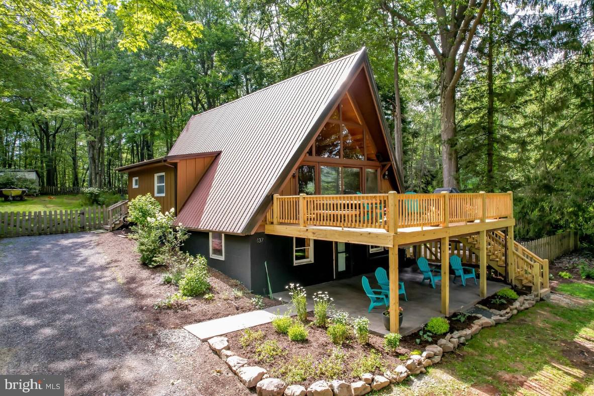Remodeled 4BR/2BA lakefront A-frame with two deep water dock slips! Impressive renovation from top to bottom, this home has everything you are seeking in a vacation home AND a huge, fenced in yard surrounded by massive trees, fire pit and storage building. Features include a massive stone fireplace (wood burning), hot tub with lake views, large kitchen with island, custom tile showers & bathrooms with cedar accents, stylish bedrooms & decor, wet bar in rec room, recently replaced deck with covered concrete patio, spacious bedrooms, whole house dehumidifier, mini-splits and some handicap accessible features.  Enjoy filtered water views though its a commanding view of your surroundings from a mountaintop perch. Located at the end of a peaceful cul-de-sac with minimal traffic but also centrally located to all lake activities. Sold furnished! Established vacation rental - 'Fox Den'