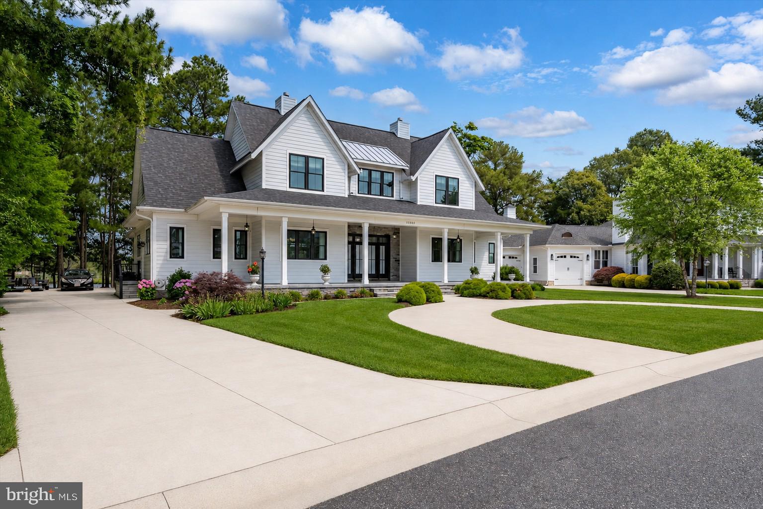 Completed in 2021, this exceptional 6-bedroom, 6 bath waterfront Modern Farmhouse offers an extraordinary blend of timeless architecture, refined finishes, and resort-style living within the prestigious gated community of Glen Riddle.  A sweeping circular driveway and expansive wraparound concrete front porch create a striking first impression before you step through the double front doors into a grand foyer, where breathtaking water views immediately capture your attention. Thoughtfully designed for both elegant entertaining and everyday living, the open-concept floor plan is filled with natural light and showcases exceptional craftsmanship throughout.  At the heart of the home is a stunning gourmet kitchen featuring an oversized quartz island, abundant custom cabinetry, premium finishes, and seamless flow into the spacious dining area and inviting great room. The family room is anchored by a gas fireplace with custom built-ins, while a separate formal living room offers additional gathering space or the flexibility to serve as a seventh sleeping area.  A private home office provides the ideal setting for remote work without sacrificing comfort or style.  The first-floor primary suite is a private sanctuary overlooking the pool and tranquil waterfront.  Two custom-designed walk-in closets provide exceptional storage, while the luxurious en-suite bath features dual vanities and a spacious roll-in shower.  Also on the main level are a generous laundry room, powder room, and direct access to the oversized three-car garage.  Designed for exceptional outdoor living, the backyard is your own private retreat.  The heated saltwater pool is notably deeper than most in the area, offering an enhanced swimming experience rarely found in coastal communities.  An adjacent pool bath adds convenience for family and guests, making entertaining effortless while keeping the home’s interior clean and dry.  The second floor offers outstanding accommodations with five additional bedrooms, three full baths, and a spacious loft that enjoys glimpses of the golf course across the street.  A versatile bonus suite, currently used as a bedroom with its own full bath and private balcony overlooking the pool and creek, is ideal as a second owner’s suite, guest retreat, or media room.  Built with both luxury and longevity in mind, the home was thoughtfully engineered to accommodate a future elevator serving both floors and the garage.  Additional premium features include two tankless gas water heaters and dual high-efficiency dual-fuel HVAC systems with gas backup, delivering year-round comfort and energy efficiency as well as a 4ft encapsulated crawlspace.  Parking is abundant with both the circular front driveway and an additional concrete driveway leading to the oversized three-car garage. The professionally irrigated lawn is maintained by the HOA, allowing for a truly low-maintenance lifestyle.  Residents of Glen Riddle enjoy an exceptional collection of resort-inspired amenities, including a beautifully appointed clubhouse with a state-of-the-art fitness center, locker rooms with saunas, billiards and game rooms, card room, meeting facilities, outdoor swimming pool with integrated spa, children’s splash pad, tennis and pickleball courts, and on-site professional management.  Golf enthusiasts will appreciate two championship golf courses and a driving range, with memberships available.  Residents may also register personal golf carts for use throughout the community, further enhancing the neighborhood’s relaxed coastal lifestyle.  Located just minutes from the pristine beaches, renowned dining, shopping, and entertainment of Ocean City, Maryland, this remarkable waterfront residence offers the rare opportunity to enjoy luxury coastal living in one of the area’s most sought-after gated communities.