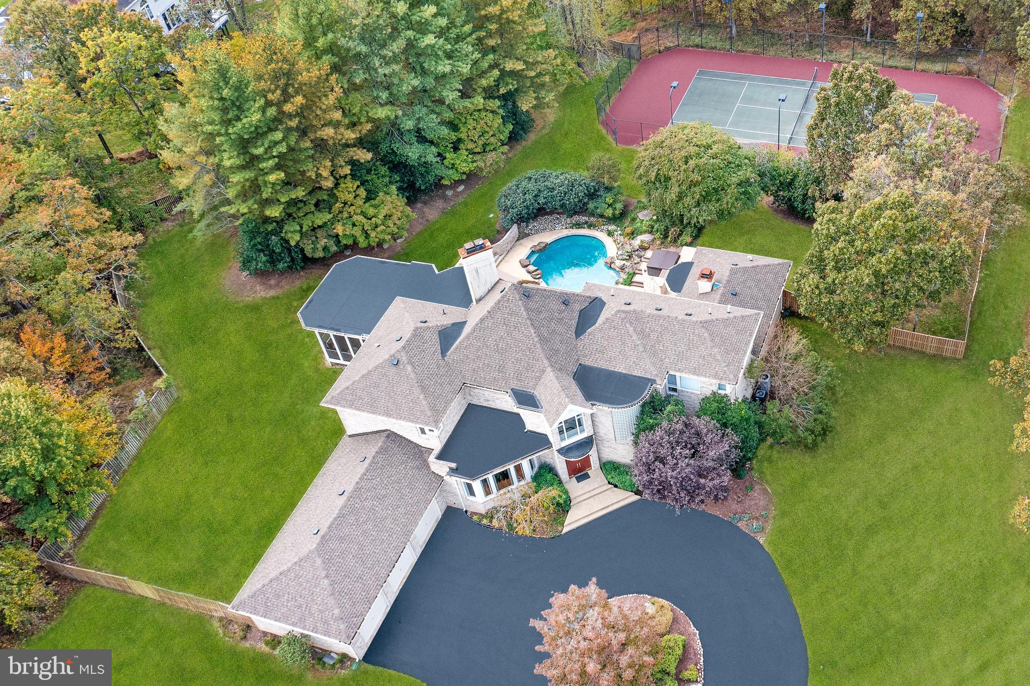 Located in one of the most prestigious neighborhoods of Potomac, this stunning contemporary home offers an extraordinary floor plan with sun-filled rooms on all three levels. Establish expectations upon arrival on the circular driveway with a captivating center garden.  As you walk through the double doors and step into the foyer with marble floors, you will be impressed with the light-drenched great room with soaring ceilings, warm hardwood floors, and a fireplace perfect for those romantic winter nights. Usher, your holiday guests in the gourmet kitchen, outfitted with Viking, Bosch, and Sub-Zero professional appliances, granite countertops, an island with seating, a bright breakfast area, an adjacent sunroom, and a huge, dramatic covered screened-in porch that provide great options for casual get-togethers or special occasions. The terrific first-floor owner's retreat has private access to the beautiful backyard terrace and features a pristine spa-inspired bathroom with a jacuzzi tub, large shower, His and Hers water closets, a super-sized walk-in closet, and a two-sided fireplace. The adjoining room could be used for the much-needed work-from-home office space/yoga/TV room or kids play area. The fabulous 3200 sq ft bright, and sunlit basement boasts a wet bar area with a gorgeous granite surround fireplace, gorgeous tray ceilings,  a movie room, game room, dance/exercise room, and an in-law suite with a large walk-in closet and full bathroom, and an additional powder room for guests. This spectacular basement is an entertainer's dream! Just grab a glass of wine or cocktail and step out to the resort-like fenced backyard with a plethora of specimen plantings and mature trees, and features a beautiful free-form inground heated pool and a fabulous lighted private tennis court which could be converted to a pickleball court(s)! The home is gracefully appointed with four sunlit bedrooms on the upper level, two ensuite bathrooms, and one jack and jill bathroom. This house meets today's new lifestyle, providing the right mix of openness, flex space, privacy, convenience, and comfort for every family member! You will not want to miss out on owning this exquisite one-of-a-kind home in the desirable Palatine community!