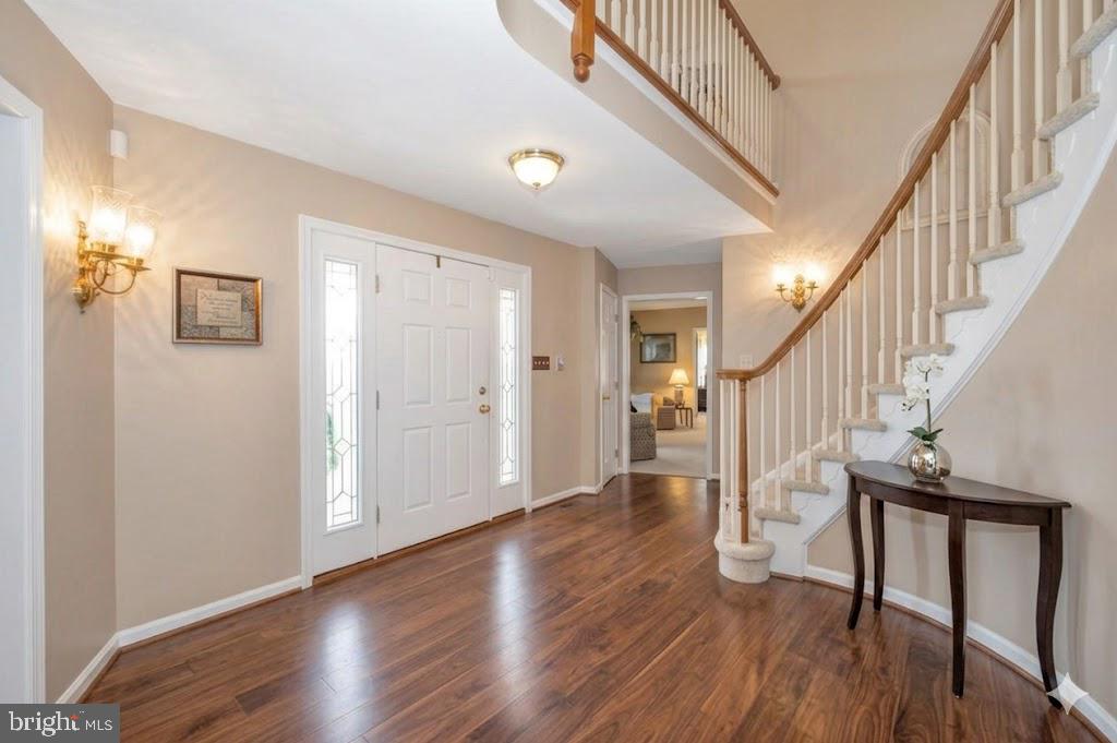 Elegant and  welcoming!  Come home to this spacious single-level living in this Ausherman-built brick rancher with bonus upper level!  Floor plan is perfect combination of open living with private areas too.  As you pull up to this beauty, you will be greeted by the rolling front yard and park next to the three-car garage.  The portico welcomes you to come into the spacious foyer with spiral staircase. To the right, you have a traditional feel of living room with adjoining dining room.  Heading straight back, you will see a grand kitchen with granite, center island with seating, and separate breakfast space.  To the left of the kitchen is a light-filled sunroom which provides exit to the deck overlooking the back yard.  Back inside, as you walk from the kitchen towards the front door, you will step down into a cozy family room with wood-burning fireplace.  The back of the family room opens to a small hall, home to the primary bedroom and bath,  and laundry.  From the entry immediately to the left is a pass-through library leading to the 2nd bedroom (now used as a home office).  A powder room is just to the right.  Climbing the spiral staircase, the upper level opens to a private study area overlooking the front yard.  Two additional bedrooms and a full hall bath complete the upper level.  The lower level of the home is used primarily for storage at this time, but some areas are partially finished.  There is a full rough in for a future bath and a walkout to the yard.