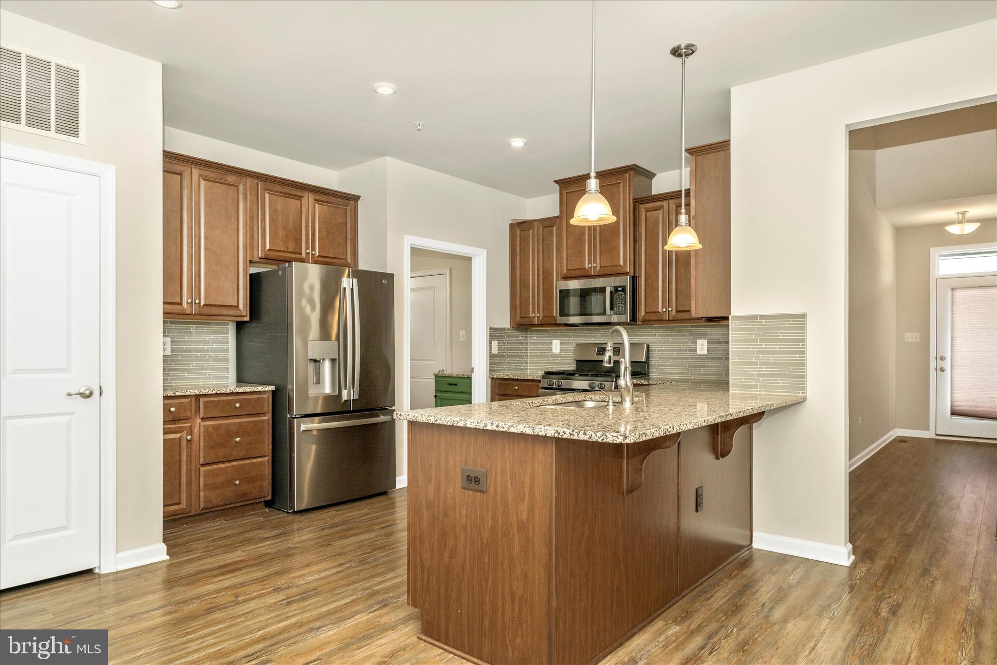 Buyers, ask about lender offered 1 year rate buy down! Terrific two-car garage villa in 55+ Tanyard Shores active community. Main level primary bedroom suite and laundry on main mean one level living. The upper level has two bedrooms and office space, plus a full bath. The lower level has a spacious efficiency apartment with kitchenette and full bath as well as a large storage/utility room. Enjoy outdoor living on your private deck that backs to a wooded area. Age in place with the Harbor House Community Center immediately next door to you. Enjoy the fitness center, yoga room, social club, outdoor community seating/grilling areas, outdoor fitness circuit, community garden, and much more. One owner/occupant needs to be 55+, others can be younger.