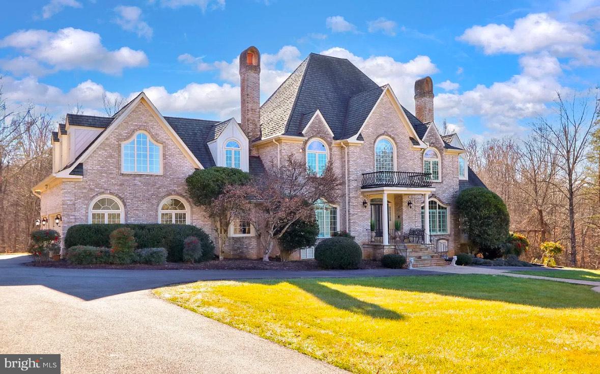 Welcome to 6601 Stonecrest Lane, a stunning custom French country chateau on 5 private acres in Fairfax Station, VA, offering luxury, elegance, and resort-style living. This 5-bedroom, 4.5-bath masterpiece features a stately three-sided brick exterior, a grand two-story foyer with hand-laid marble floors, and an inviting winding staircase. The gourmet chef’s kitchen boasts granite countertops, handcrafted cabinetry, double wall ovens, and a commercial-grade refrigerator, while the two-story great room with a fireplace and formal dining room with wainscoting and a candelabra chandelier provide the perfect spaces for entertaining. The primary suite is a lavish retreat with cathedral ceilings, dual vanities, a soaking tub, and a spa-like glass-enclosed shower, while the junior suite with a private bath and separate staircase makes for an ideal au pair or in-law suite. The walkout lower level offers a spacious recreation room, two bonus rooms, a steam shower, and ample storage. Outside, enjoy a multi-tiered deck, in-ground pool, hot tub, water feature, and lush landscaping—a perfect oasis for relaxation and gatherings. Ideally located near major commuter routes, Burke VRE, and the charming Town of Clifton, this exquisite estate seamlessly blends sophistication, comfort, and convenience. Some photos have been virtually staged to help showcase the potential of each space. Don’t miss this rare opportunity—schedule your private tour today!