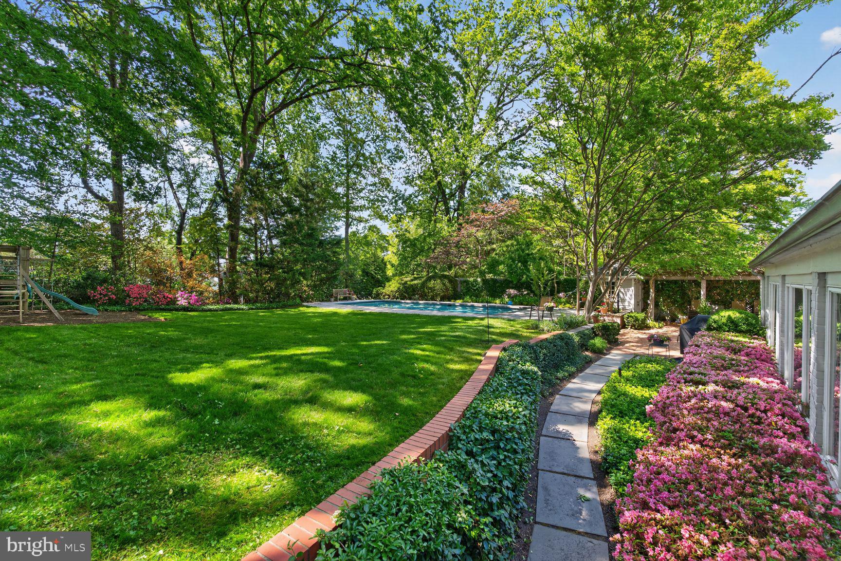 NEW PRICE!! Graceful  Georgian Colonial residence,  beautifully maintained and sited on a generous 1/3-acre, (DOUBLE) fully usable, unique lot with fabulous Pool, offering nearly 5,000 total square feet.  
The entry level offers exceptional flexibility, highlighted by its beautiful living room with custom built-in shelving and direct access to a charming courtyard garden,  a second kitchen and casual dining area, and a room that can serve as a bedroom or library with a fireplace, along with a full bath.
 This level also provides direct access to a two-car garage, enhancing both convenience and functionality.  
The second level features a second gracious living room, or formal dining room, adjacent to a lovely sunroom connecting to the well appointment kitchen and dining area with direct access to the large brick rear patio, with trumpet vine-covered pergola, 15x32 pool and a stunning Lila Fendricks-designed back garden—private and perfect for effortless indoor-outdoor living. 
A separate family room on the main floor has a dramatic vaulted ceiling and huge window adding warmth with immense architectural interest, inviting gathering and relaxation. Plus a full bath
The expansive primary suite offers a private retreat, complete with office or sitting room and fireplace, lovely bedroom and petit balcony, dressing area, and a fully appointed bath including a steam shower. 
3 additional bedrooms and baths provide ample space for all occupants & guests!
This is a "must see" property!