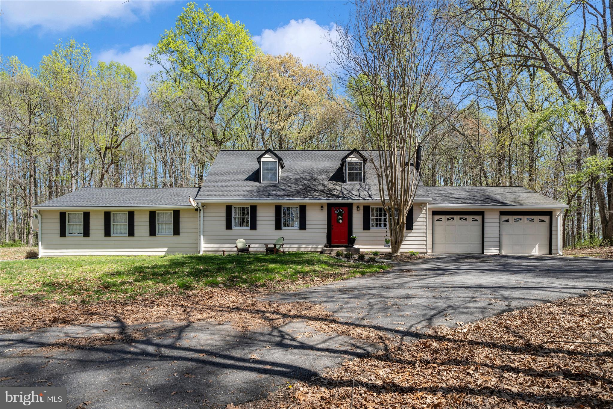 Tucked beside Lake Frank and just minutes from Lake Needwood and Rock Creek Regional Park, this stunning Cape Cod offers three beautifully wooded acres of privacy without sacrificing a single convenience. It's a rare find — a true nature lover's retreat with easy access to Metro, MARC Rail, and the ICC.
Inside, vaulted ceilings give the living room an open, airy feel that flows naturally into the family room and kitchen, creating a layout ideal for both relaxed evenings and effortless entertaining. A sun-drenched all-seasons sunroom off the kitchen opens onto a back deck complete with a hot tub, where towering trees and the sounds of nature greet you in every season. Two bedrooms and two full baths round out the main level. Upstairs, a generous loft and bonus room provide the kind of flexible space that adapts to whatever you need — a home office, guest suite, or playroom. Fresh paint and new carpet in the loft make this home move-in ready! 
Car enthusiasts and hobbyists will love the dual-garage setup: an attached two-car garage accessible from the kitchen, plus a second garage off the family room featuring a commercial lift. Practical peace of mind comes courtesy of a five-year-old roof and newly installed Gutter Helmet gutters.
Whether you spend your weekends hiking, kayaking, or simply unwinding in the hot tub as the sun filters through the trees, this home delivers the best of both worlds — a serene, wooded sanctuary with the city right at your doorstep.
