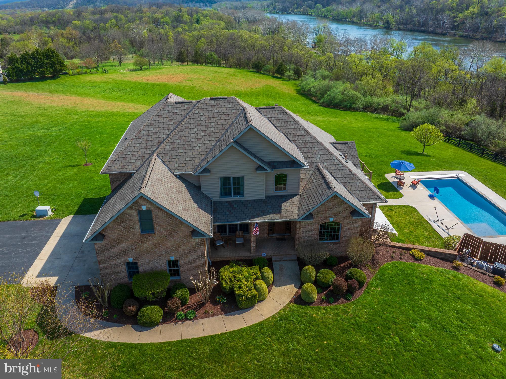Welcome to 94 Falcon Drive in beautiful Charles Town, West Virginia—an exceptional opportunity to own a private retreat on 7 scenic acres in the rolling hills of Jefferson County.--This stunning 5-bedroom, 5,725-square-foot brick contemporary home offers breathtaking panoramic views of the Shenandoah River and surrounding mountains. Thoughtfully designed to balance elegance and comfort, the home features spacious living areas ideal for both everyday living and entertaining.--Step outside to experience truly remarkable outdoor living. Expansive decks, porches, and patios create a peaceful setting, complete with an in-ground pool, hot tub, and a fully equipped outdoor kitchen—perfect for gatherings or relaxing evenings at home. The beautifully landscaped grounds, mature plantings, and impressive gated entrance provide outstanding curb appeal and privacy. Property entrance is fenced. Inside, the home boasts two fireplaces, generous living spaces, and a three-car garage. There is a whole house Generac Generator . The separate workshop shed adds flexibility for hobbies or storage. The property entrance  fenced and gated, offering both security and seclusion. There is a security alert built into the driveway that sounds whenever guests arrive. There is an abundance of space in the driveway area that can be used as a Pickle Ball Court. Conveniently located just minutes from the MARC train, this home makes commuting to Washington, D.C. effortless while allowing you to enjoy the tranquility of country living.--ASSUMABLE VA MORTGAGE 2.5 PERCENT-$300,000--This is a rare blend of luxury, space, and natural beauty—an ideal place to call home.